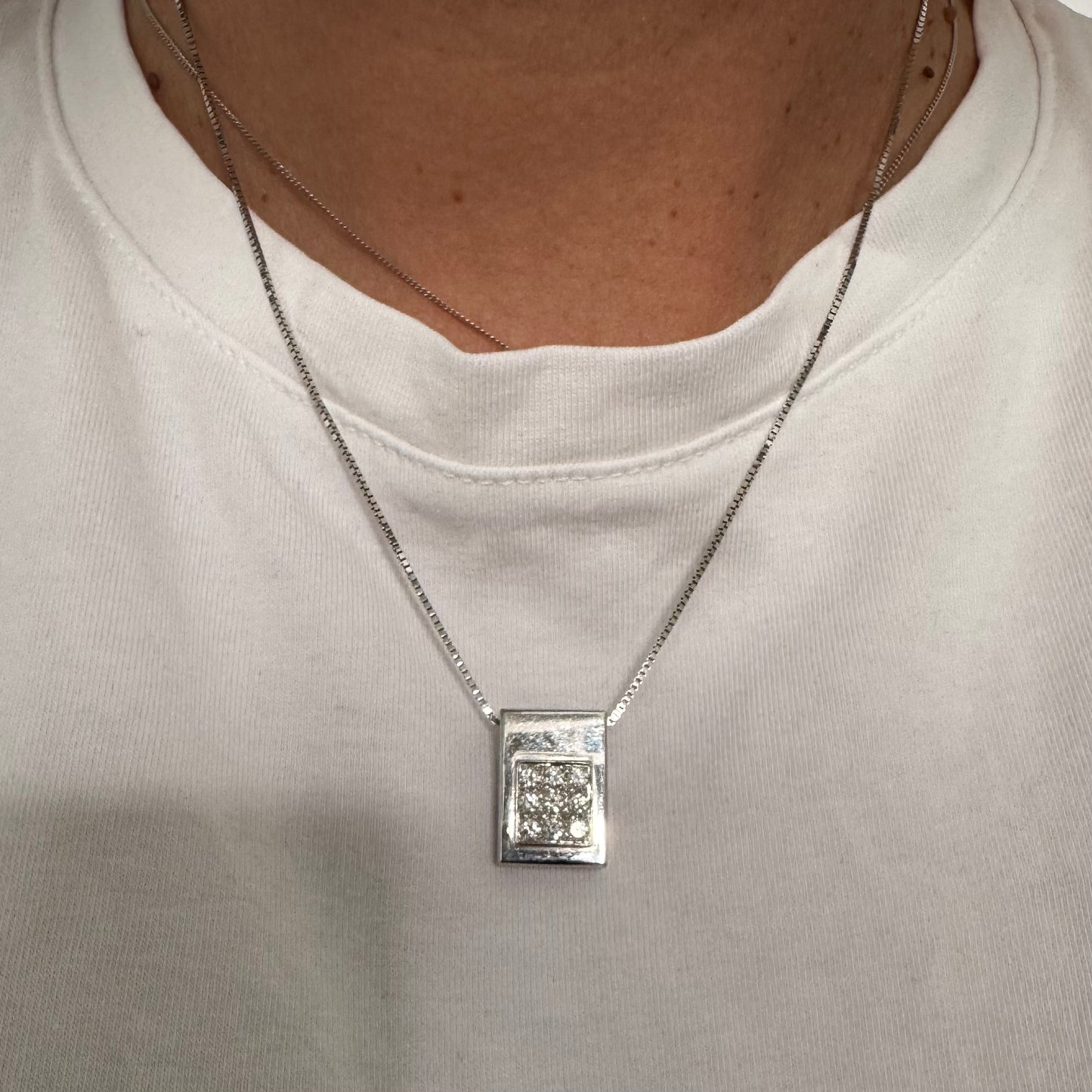 תליון זהב לבן 18 קראט משובץ יהלומים בחיתוך עגול, בשיבוץ צפוף ומדויק היוצר מראה אלגנטי ונקי. 