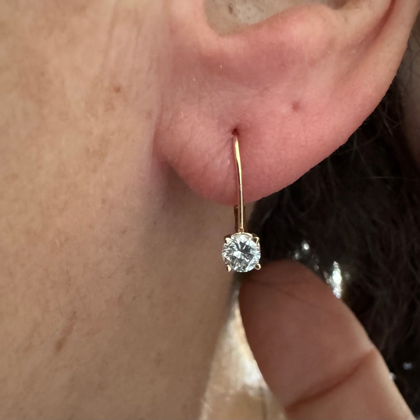 עגילי זהב 14 קראט משובצים יהלום עגול בשיבוץ קלאסי שמדגיש את האור והניקיון של האבן. 