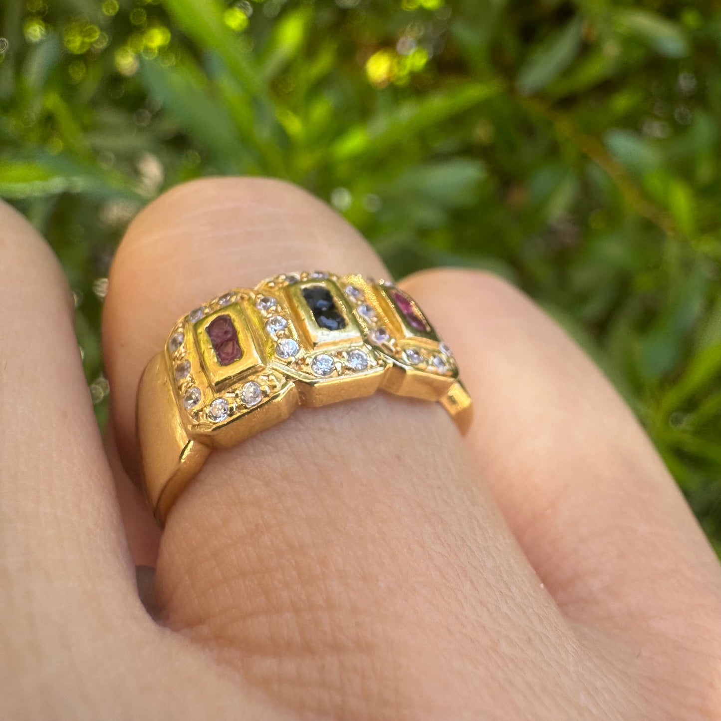 18K gold ring set with Rubies Sapphires, framed by sparkling Diamonds