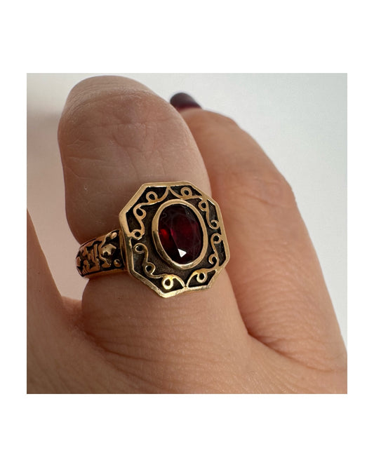 14K gold ring set with an oval deep-red Garnet.