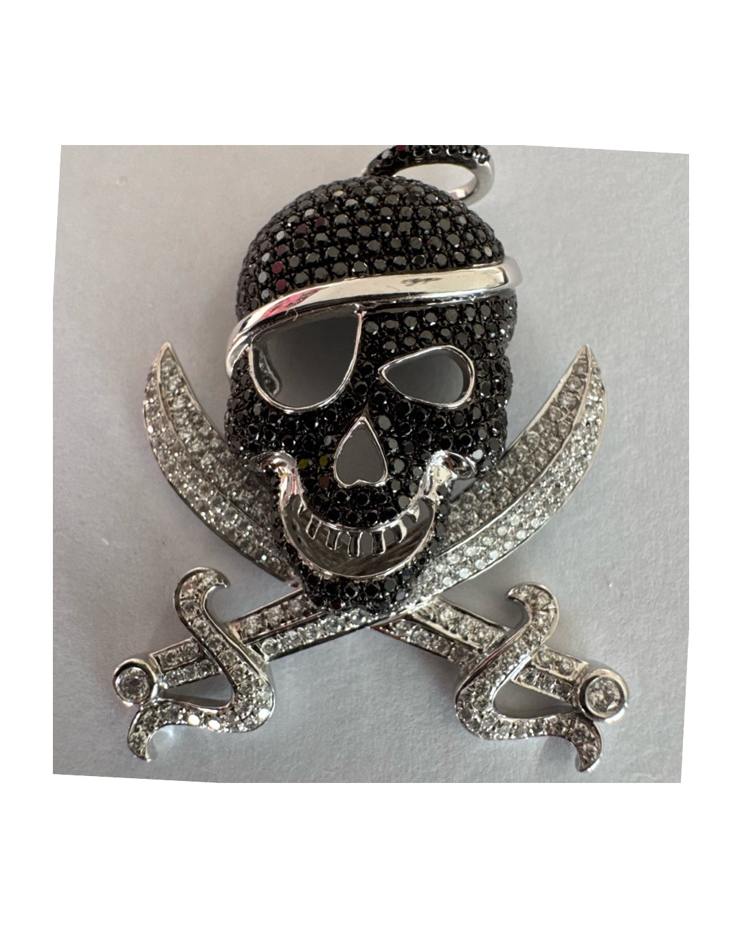 תליון זהב 14 קראט בצורת גולגולת/פיראט משובץ יהלומים לבנים ויהלומים שחורים בשיבוץ פאבה צפוף.