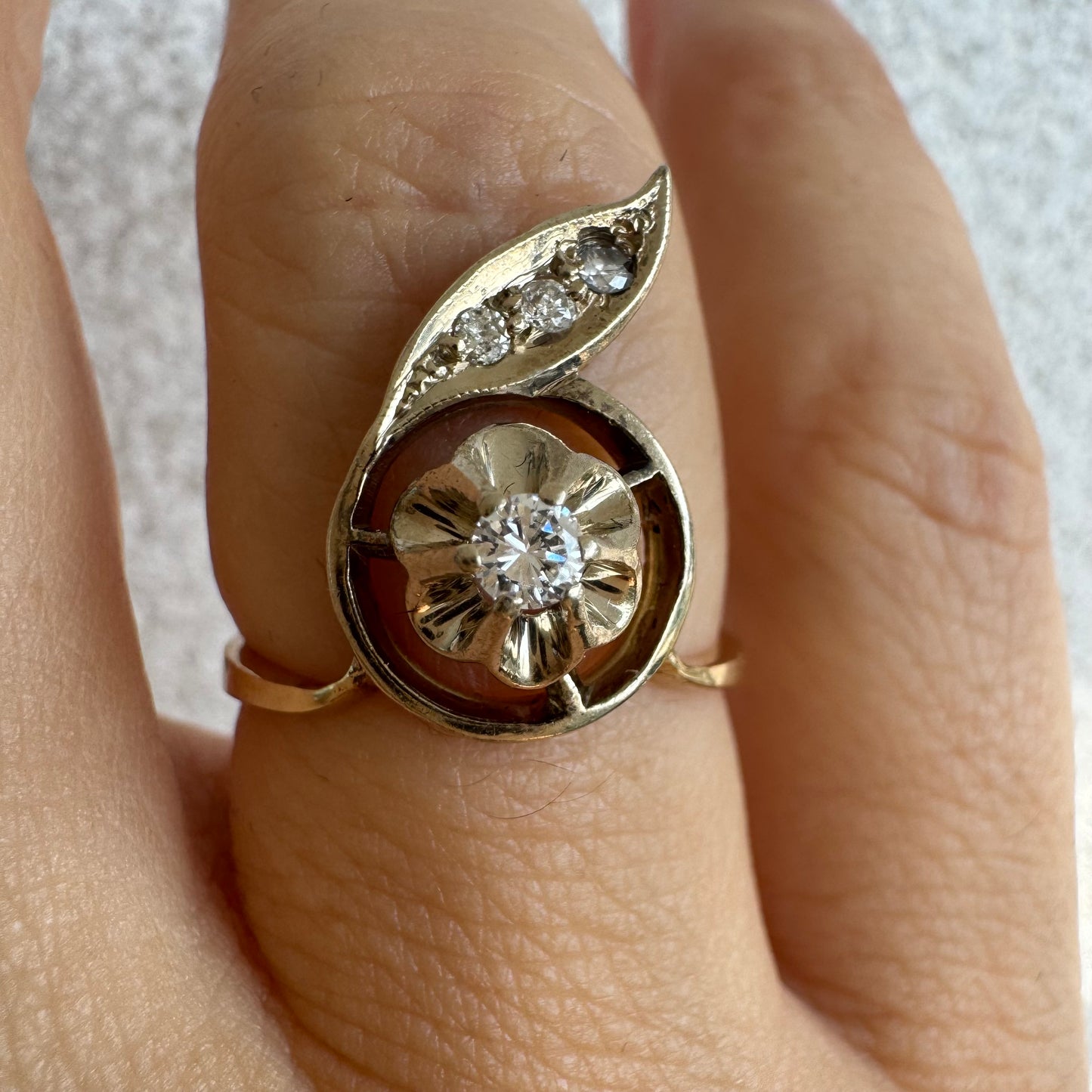 טבעת זהב צהוב 14 קראט בעיצוב פרח עדין המשובצת יהלומים נוצצים .