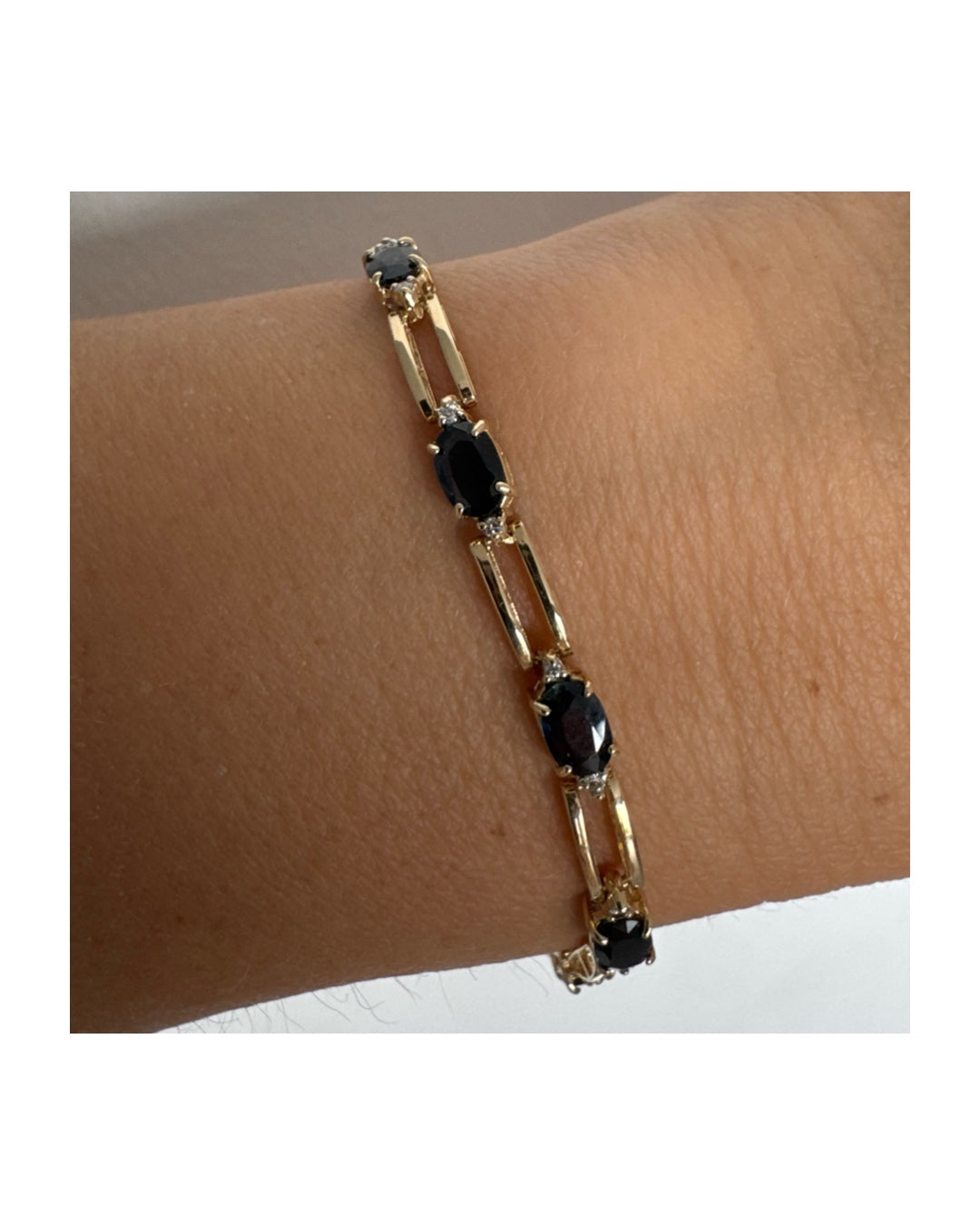 צמיד זהב צהוב 14 קראט משובץ אבני טופז כחולות בחיתוך אובלי, עם יהלומים המשובצים ביניהן להוספת ברק עדין.