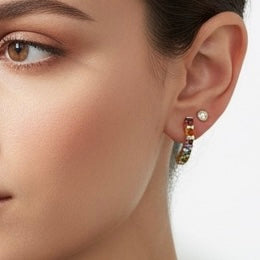 18K gold hoop earrings set with a vibrant line of multi-colored gemstones — including Garnet, Citrine, Amethyst, Peridot, and Blue Topaz.