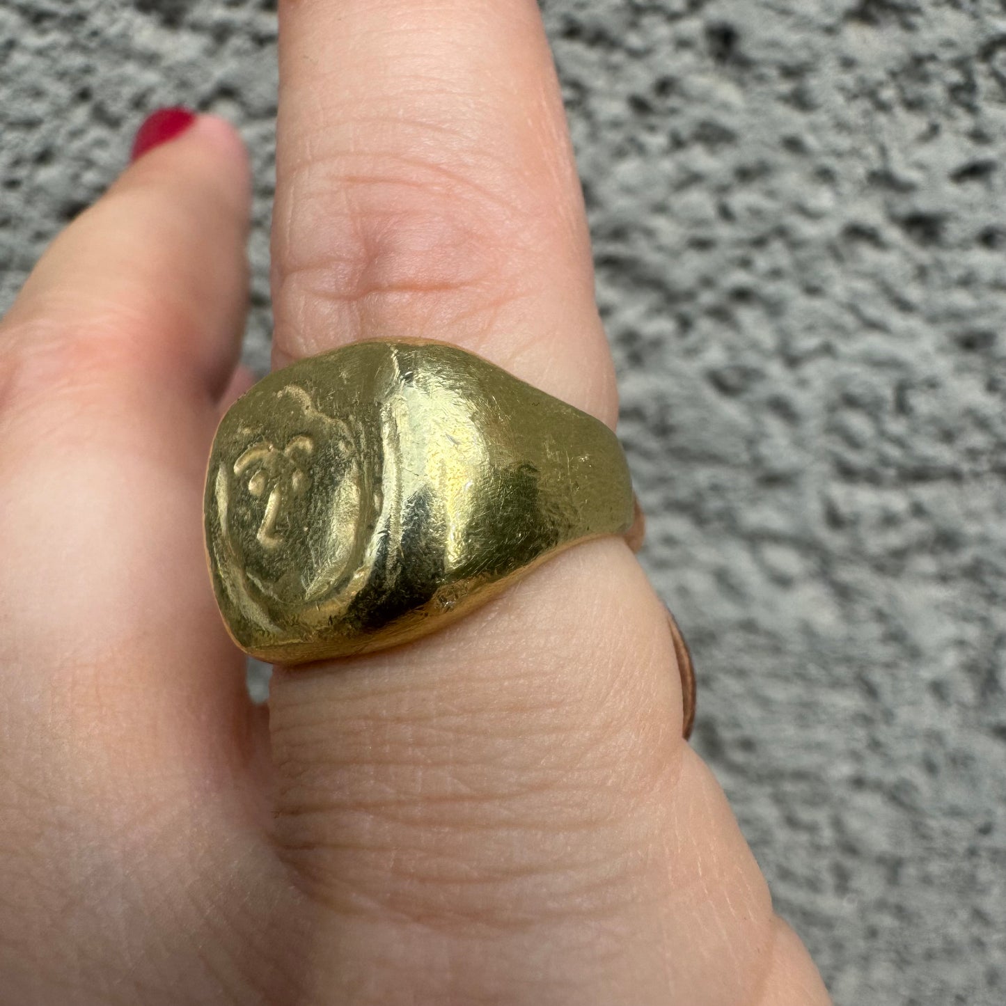 18K gold chunky gold ring with a rustic, organic finish, featuring an engraved abstract face motif at its center.