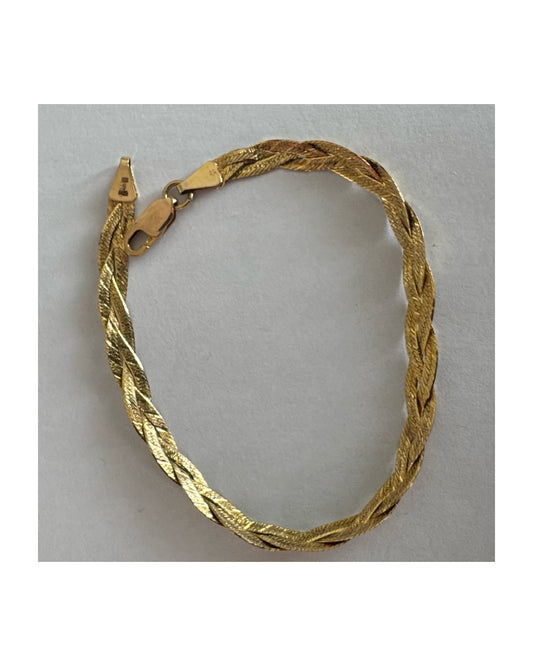 צמיד זהב צהוב 10 קראט בעיצוב קלוע עם טקסטורה עדינה שמחזירה אור וברק רך.