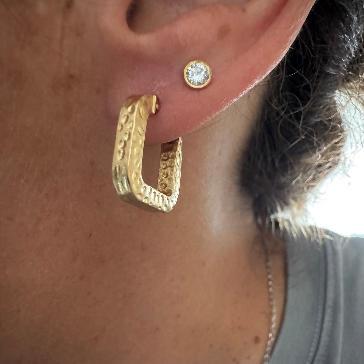 14K gold square hoop earrings with a textured, hammered finish.