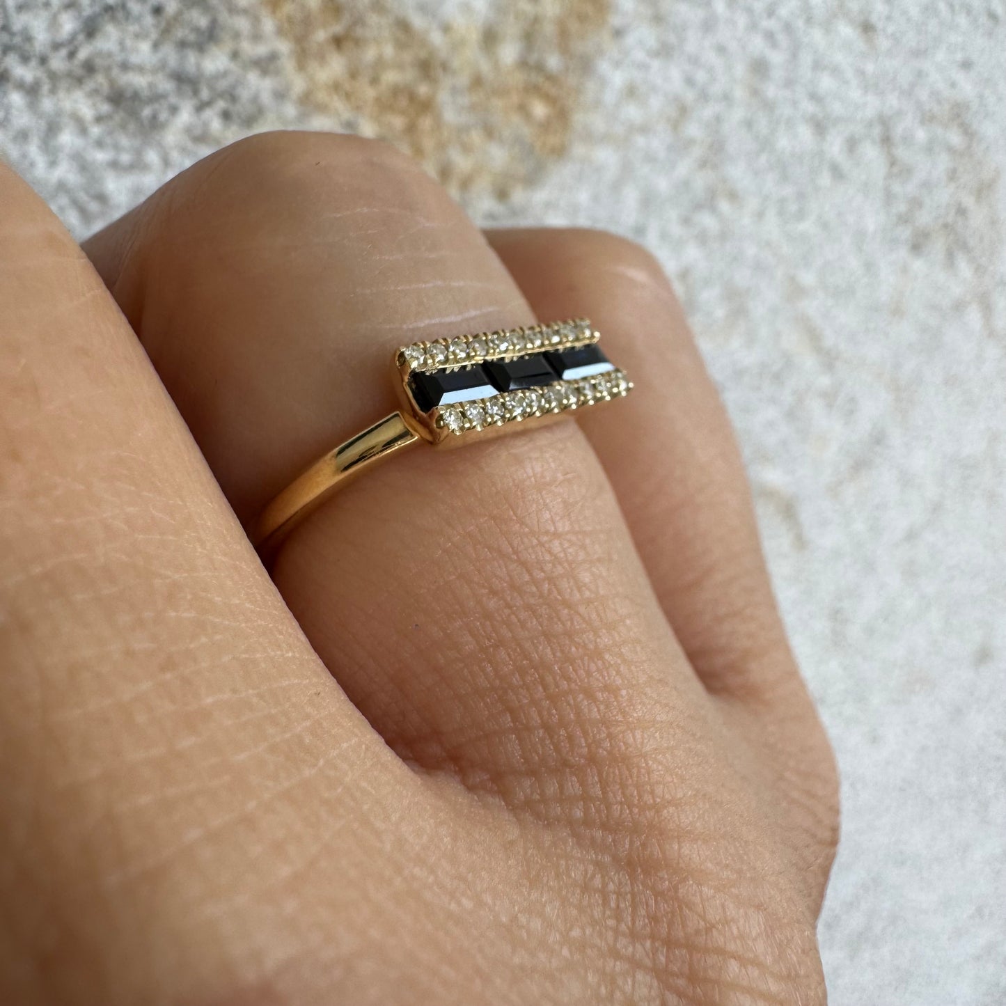 14K gold ring set with baguette-cut Sapphire framed by sparkling Diamonds