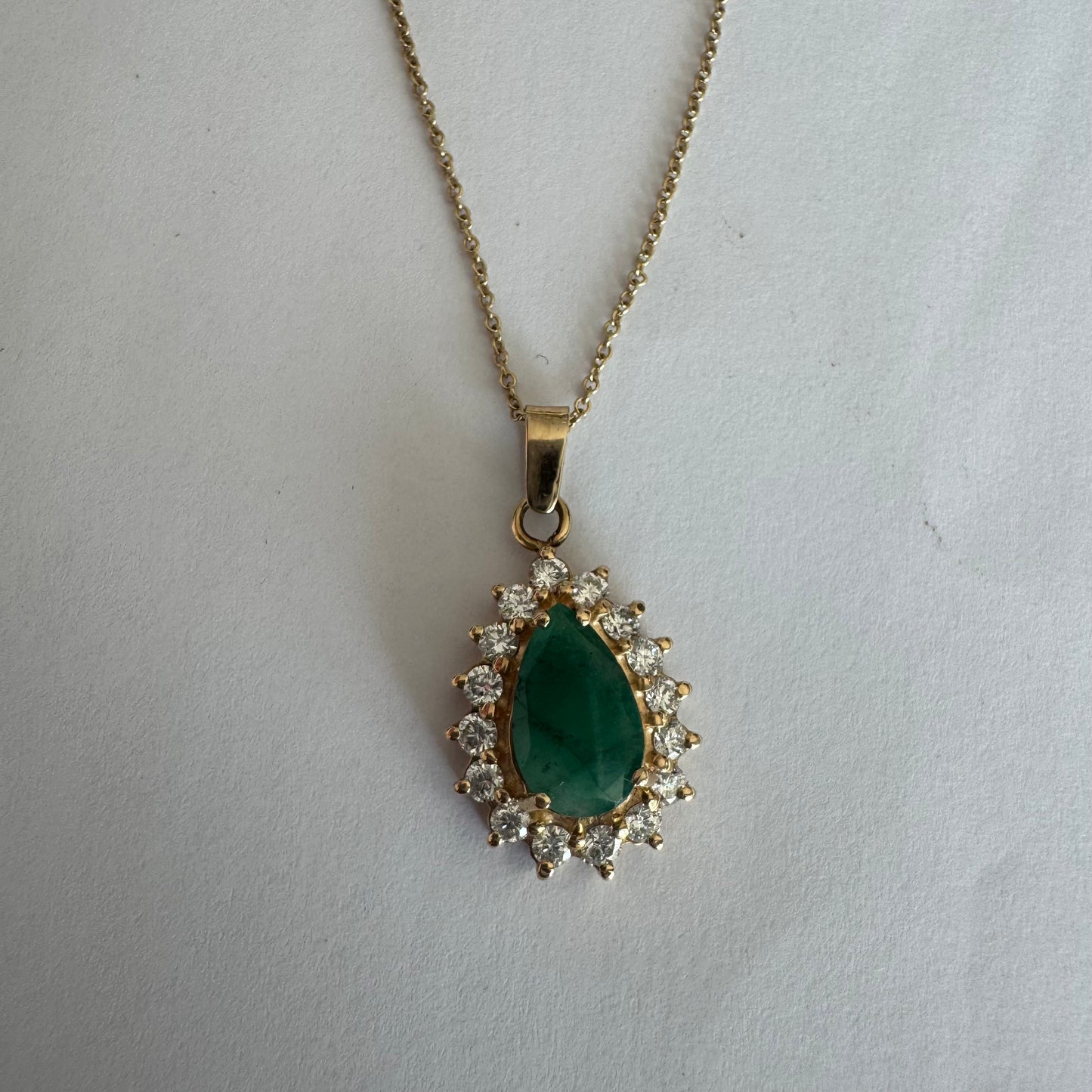14K gold necklace set with a pear-cut Emerald, surrounded by sparkling lab-grown Diamonds.