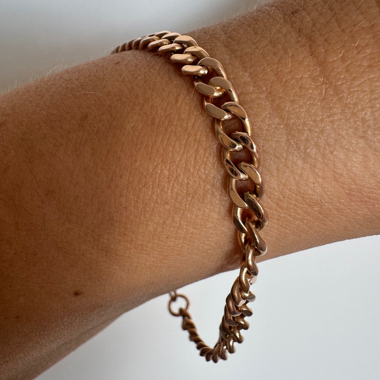 14K gold bracelet featuring a classic chain-link design with a sleek, elegant presence on the wrist.