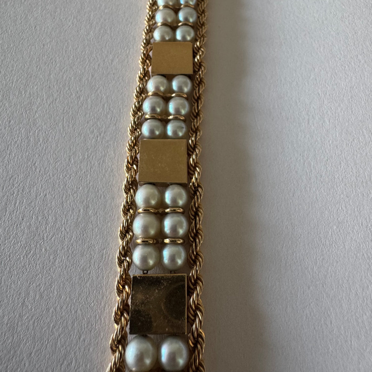 14K gold bracelet set with Pearls, featuring intricate rope-style detailing and textured geometric gold elements.
