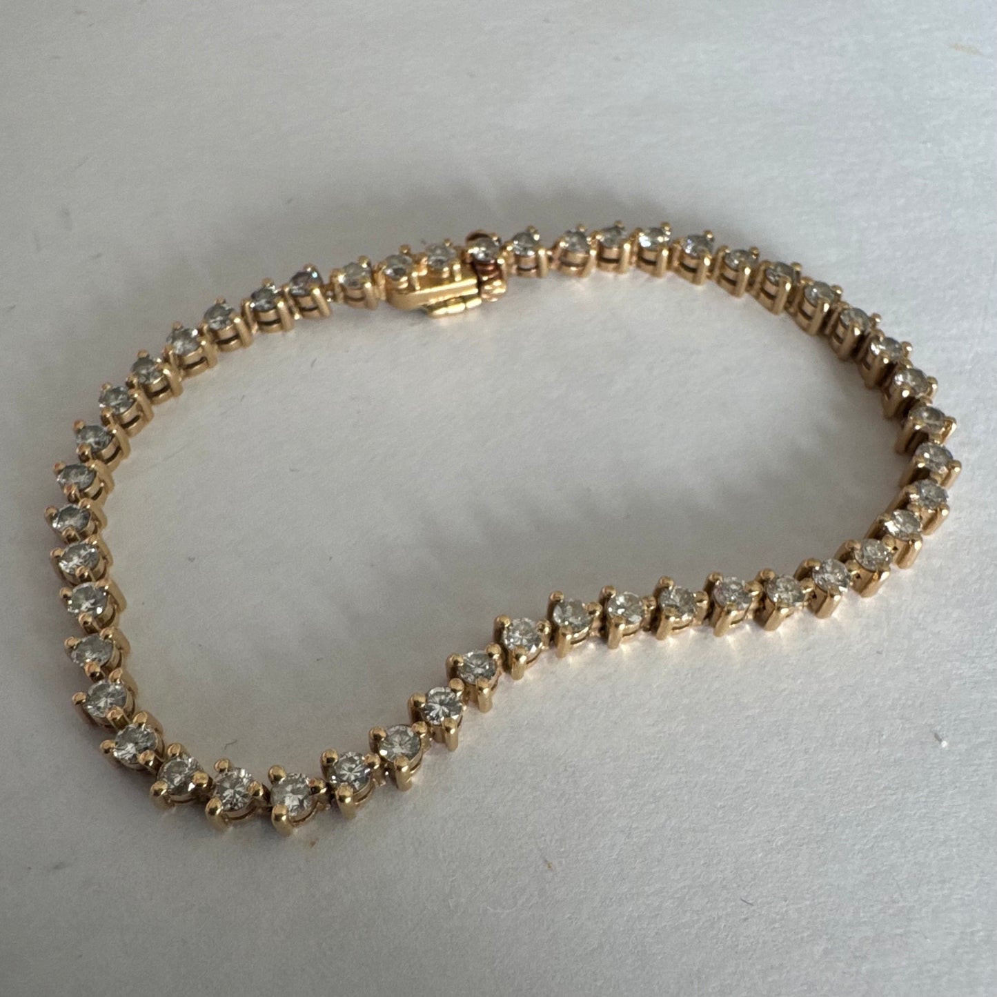 14K gold tennis bracelet set with a continuous line of round Diamonds, creating a delicate and elegant sparkle.