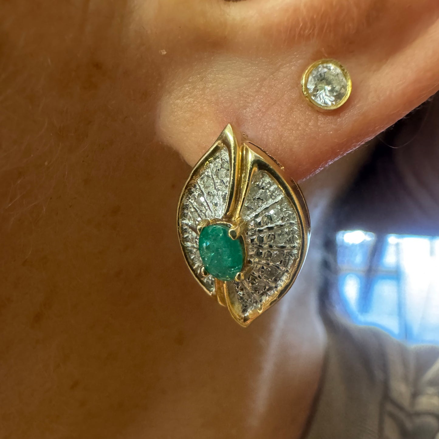 14K gold drop earrings in a refined leaf design, set with vivid green Emeralds at the center and shimmering pavé-set Diamonds along the curves