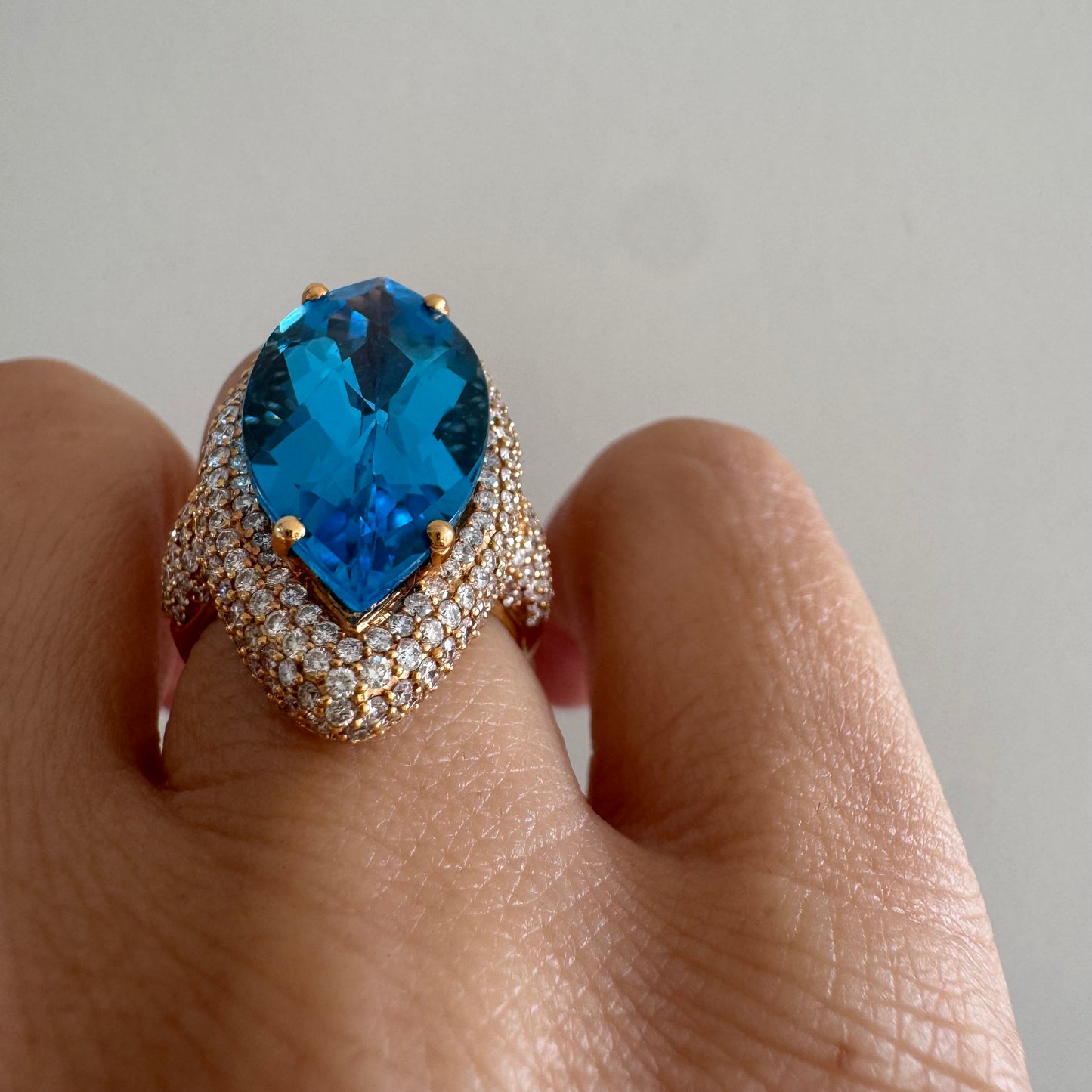 18K gold ring set with a large marquise-cut Blue Topaz gemstone, surrounded by sparkling Diamonds