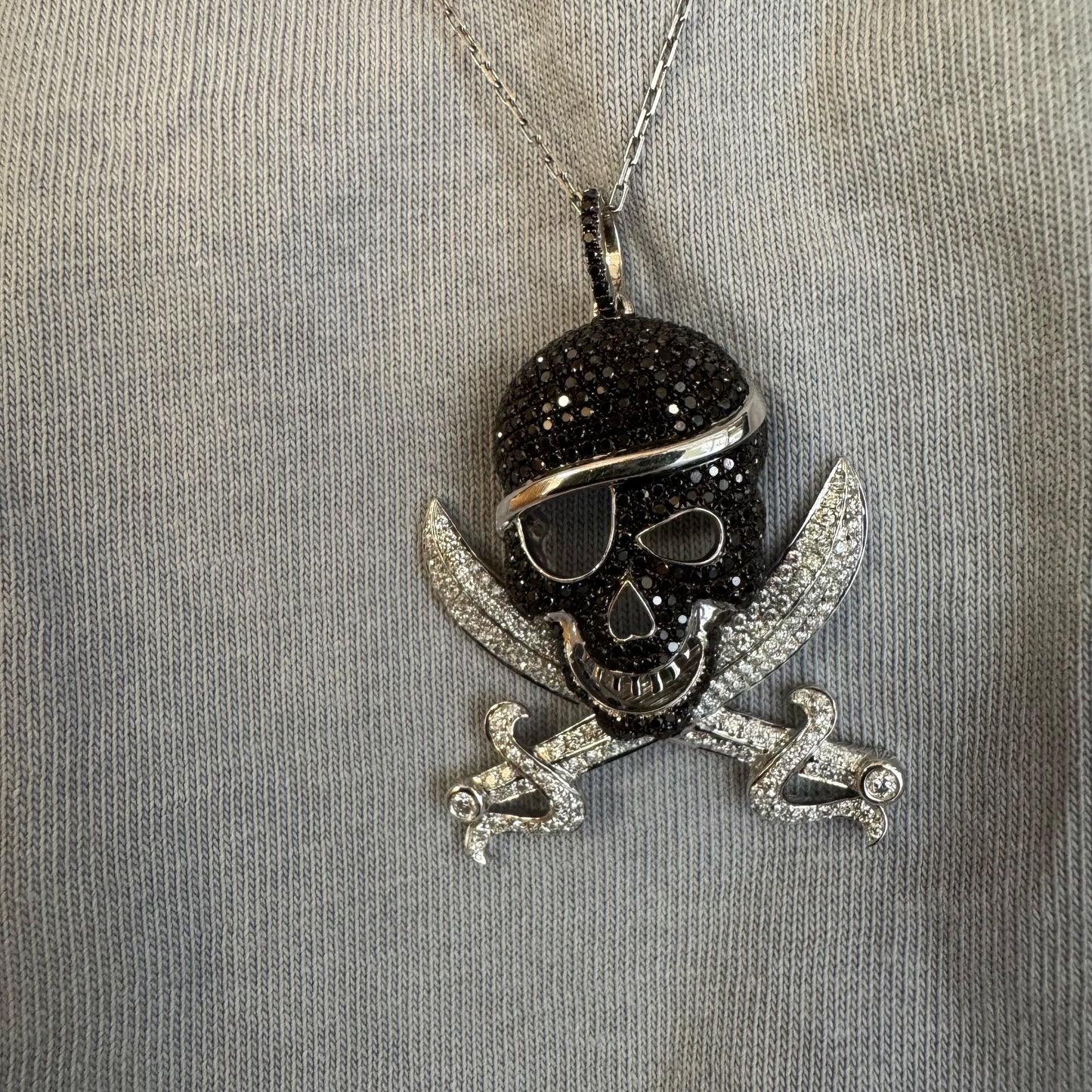 תליון זהב 14 קראט בצורת גולגולת/פיראט משובץ יהלומים לבנים ויהלומים שחורים בשיבוץ פאבה צפוף.