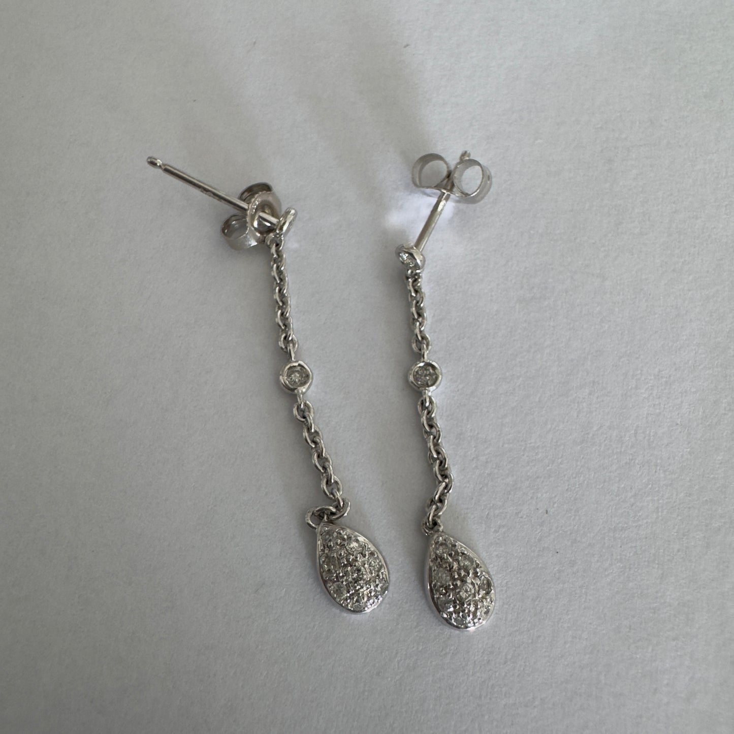 14K gold drop earrings featuring a delicate chain design with sparkling teardrop pendants.
