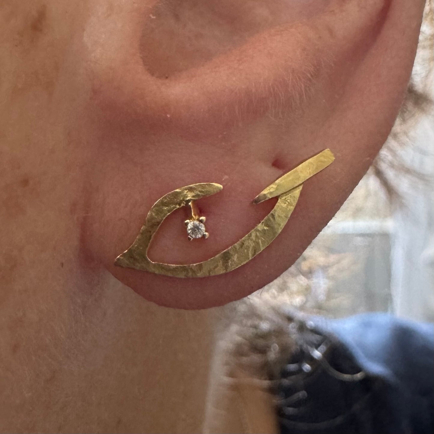 18K gold earrings in an abstract and elegant design featuring a unique handcrafted texture and a delicate Diamond set at the center