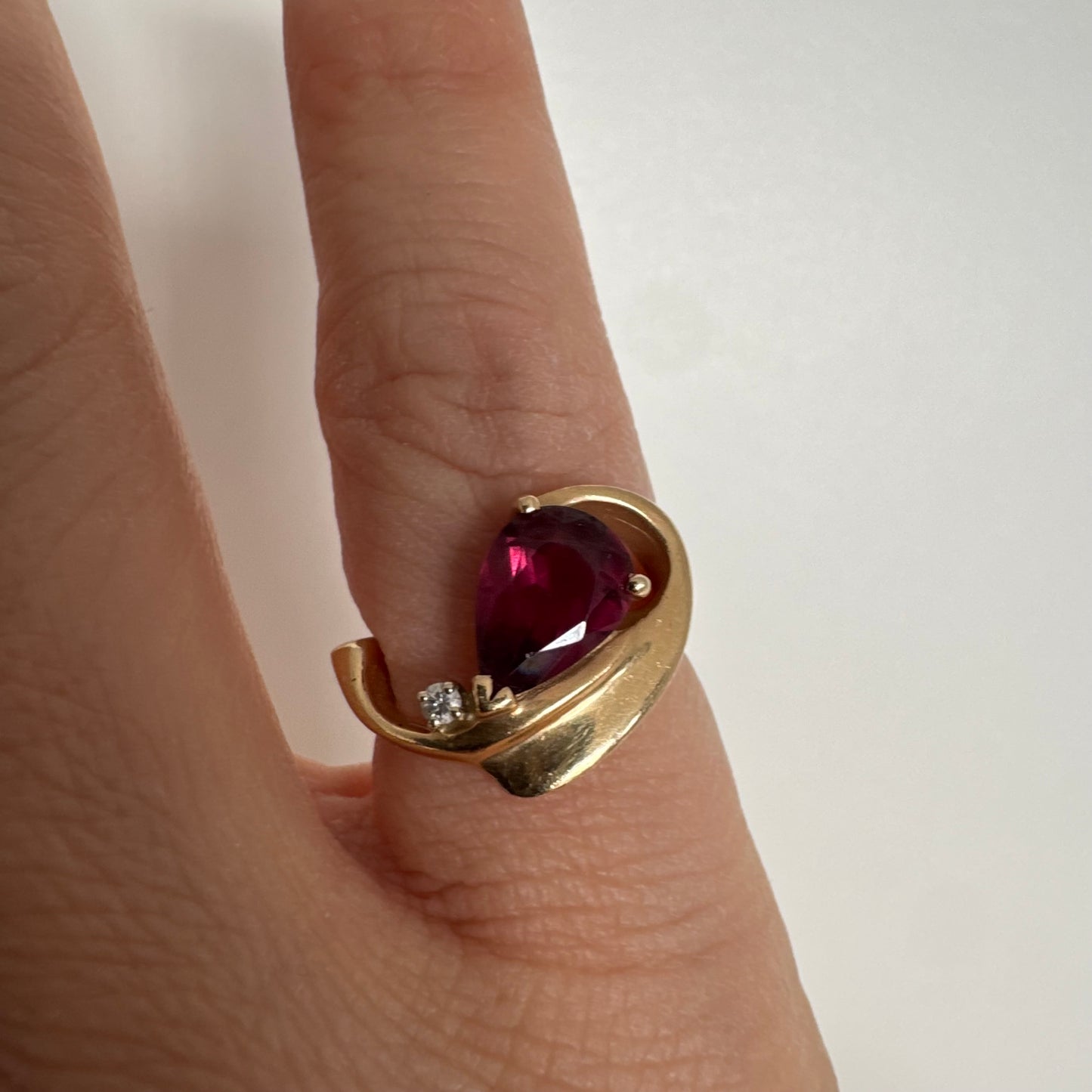14K gold sculptural open ring set with a pear-cut pink Tourmaline, accented by a small Diamond.