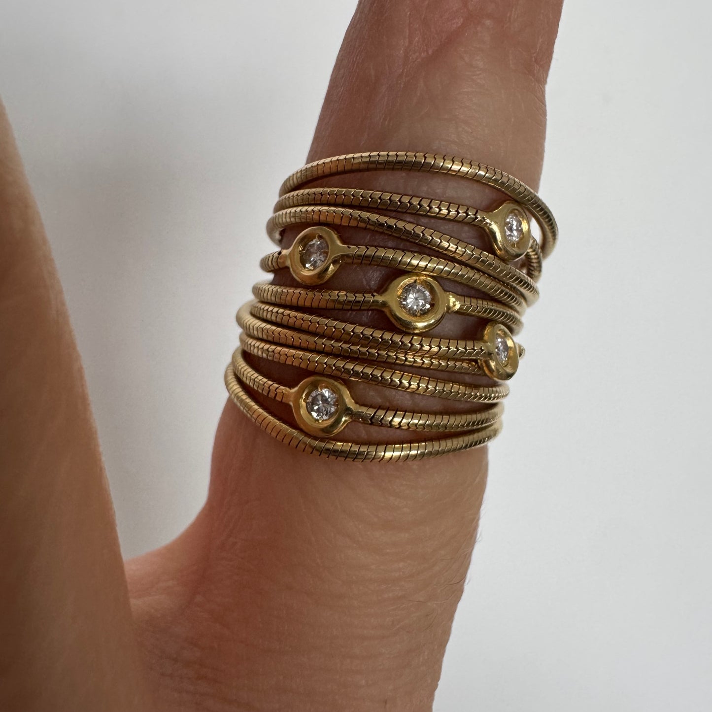 טבעת זהב צהוב 18 קראט של המותג H. Stern משובצת יהלומים בעיצוב רב־ליפופים אלגנטי 