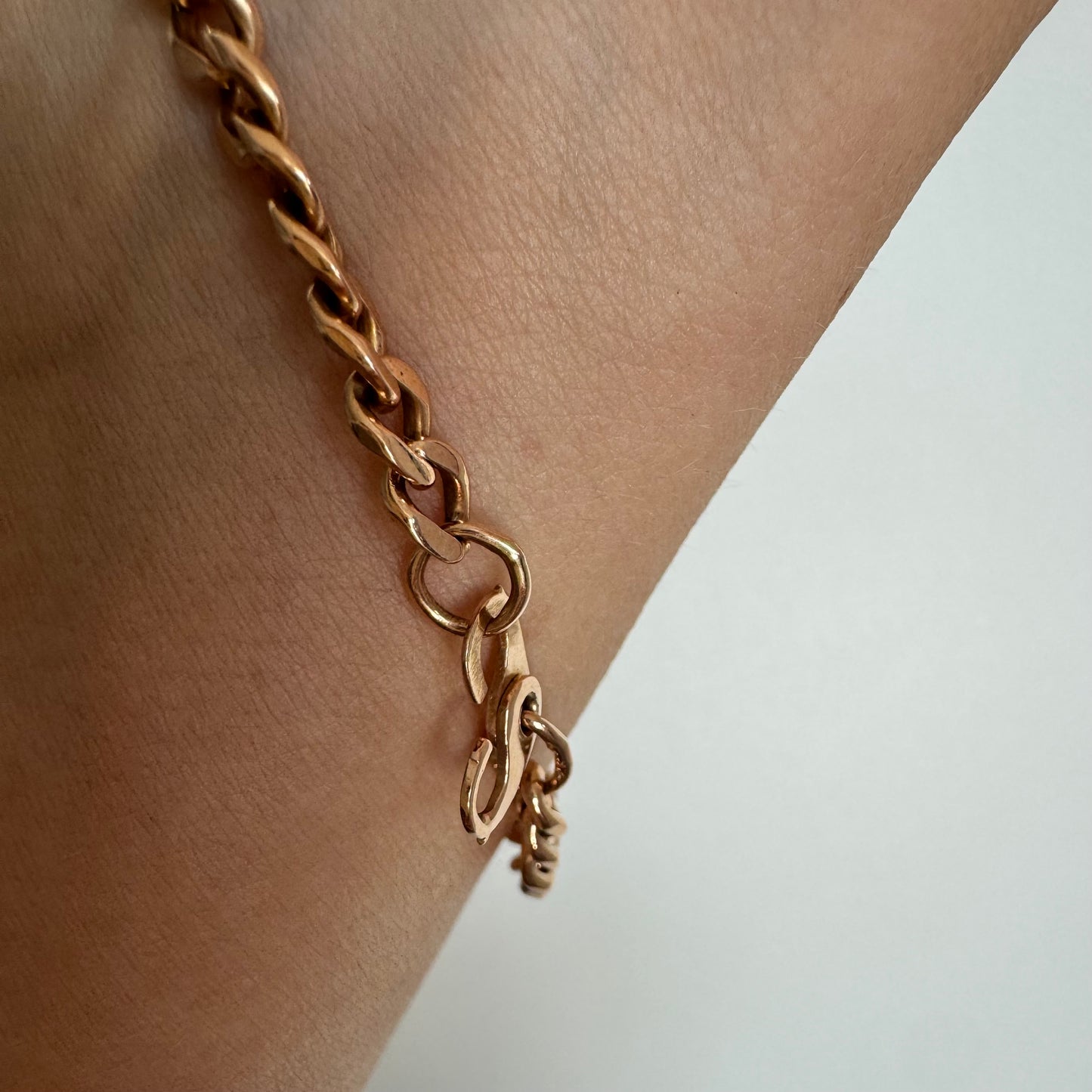 14K gold bracelet featuring a classic chain-link design with a sleek, elegant presence on the wrist.