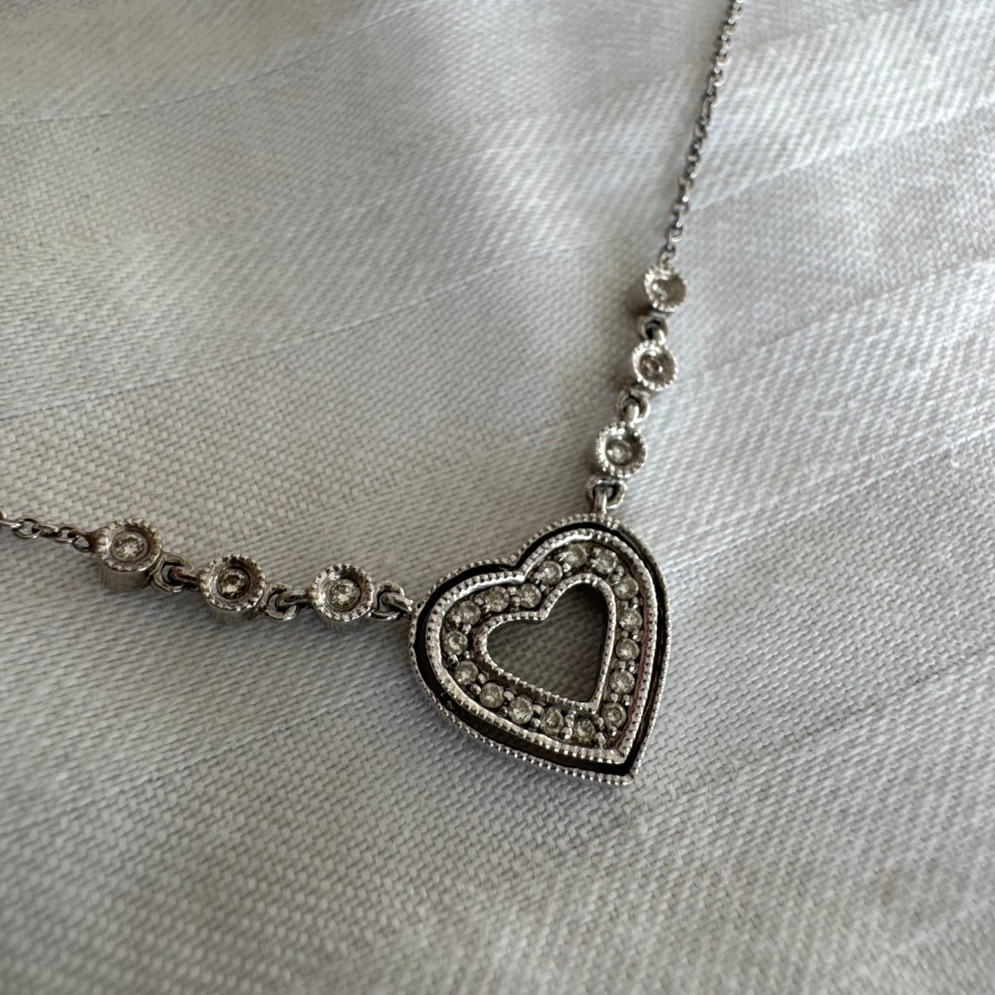 שרשרת זהב לבן 14 קראט משובצת יהלומים, בעיצוב לב עדין ומלא רומנטיקה.