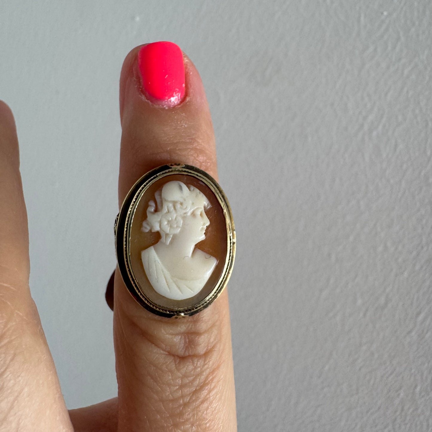 14K gold cameo ring featuring a finely carved portrait of a woman in profile, set in an oval bezel with intricate gold detailing