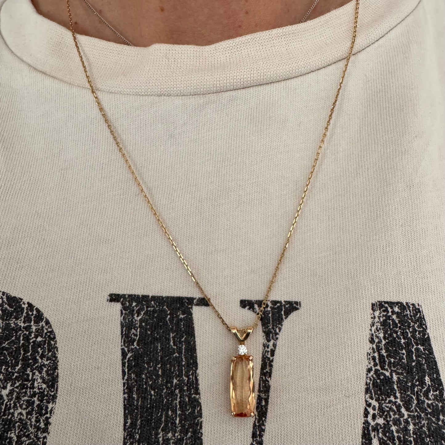 שרשרת זהב 14 קראט עם תליון זהב 14 קראט משובץ אבן קוורץ מלבנית בגוון שמפניה חמים, ומעליה יהלום נוצץ להדגשה עדינה של הברק.