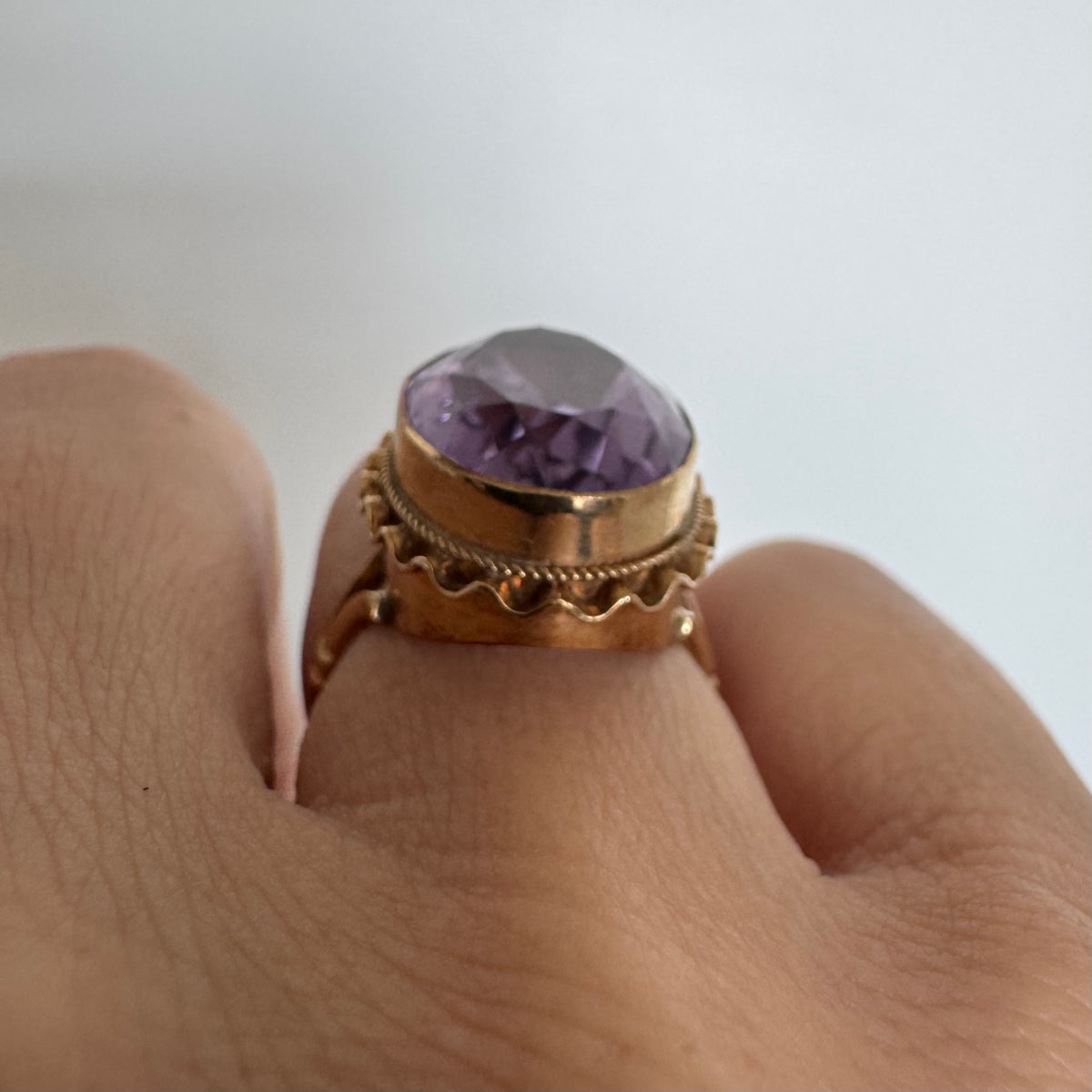 14K gold ring featuring a large oval-cut Amethyst set in an beautifully detailed gold setting