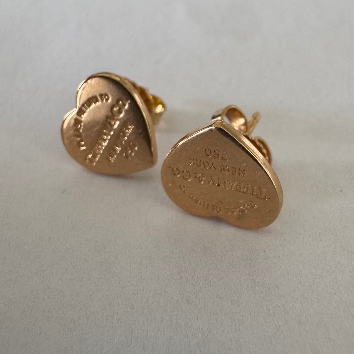 עגילים צמודים של Tiffany &amp; Co. עשויים זהב 18 קראט (750), בעיצוב לב אייקוני עם חריטת “Please Return to Tiffany & Co. New York”. 