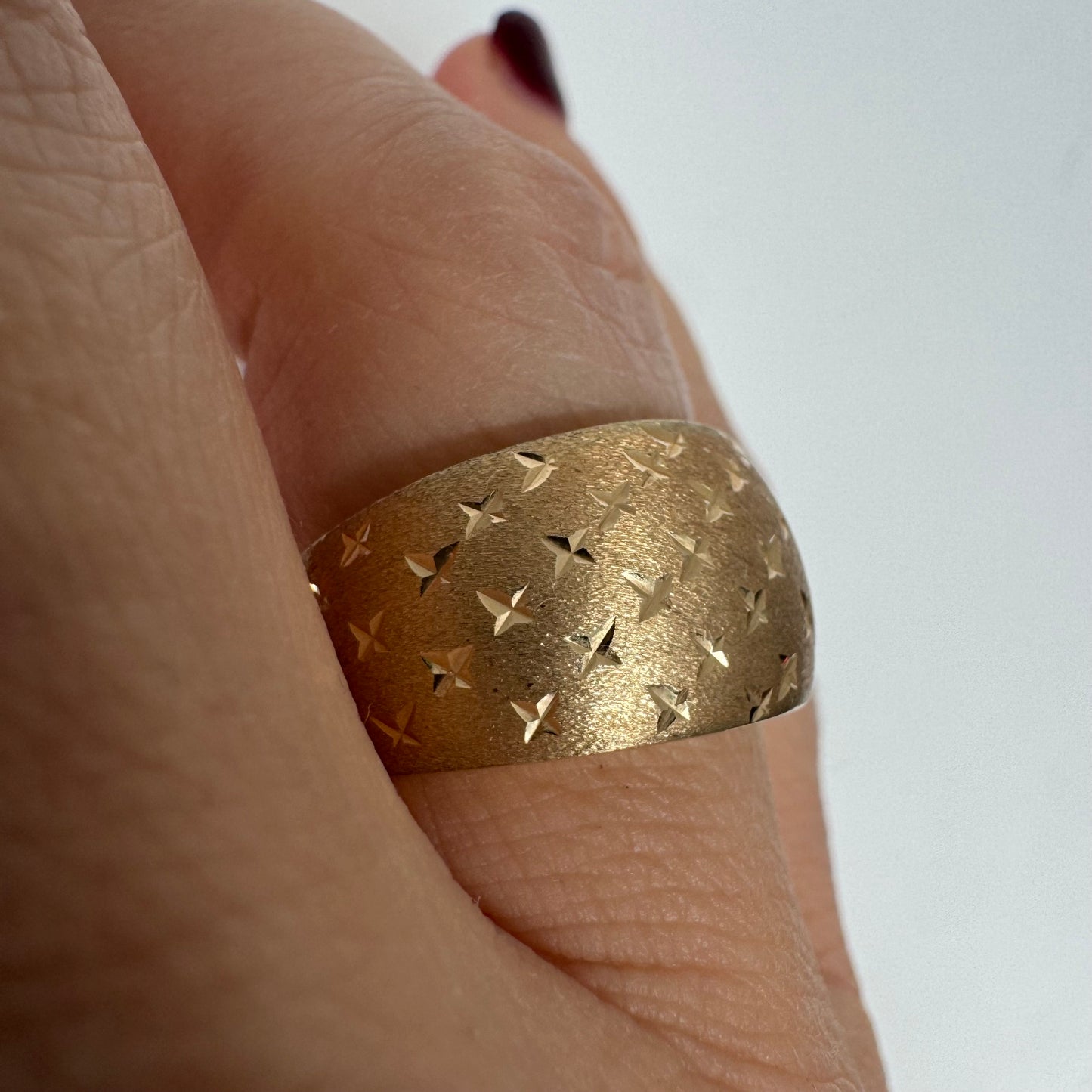 14K gold wide signet-style ring with a matte finish and delicate star engravings.