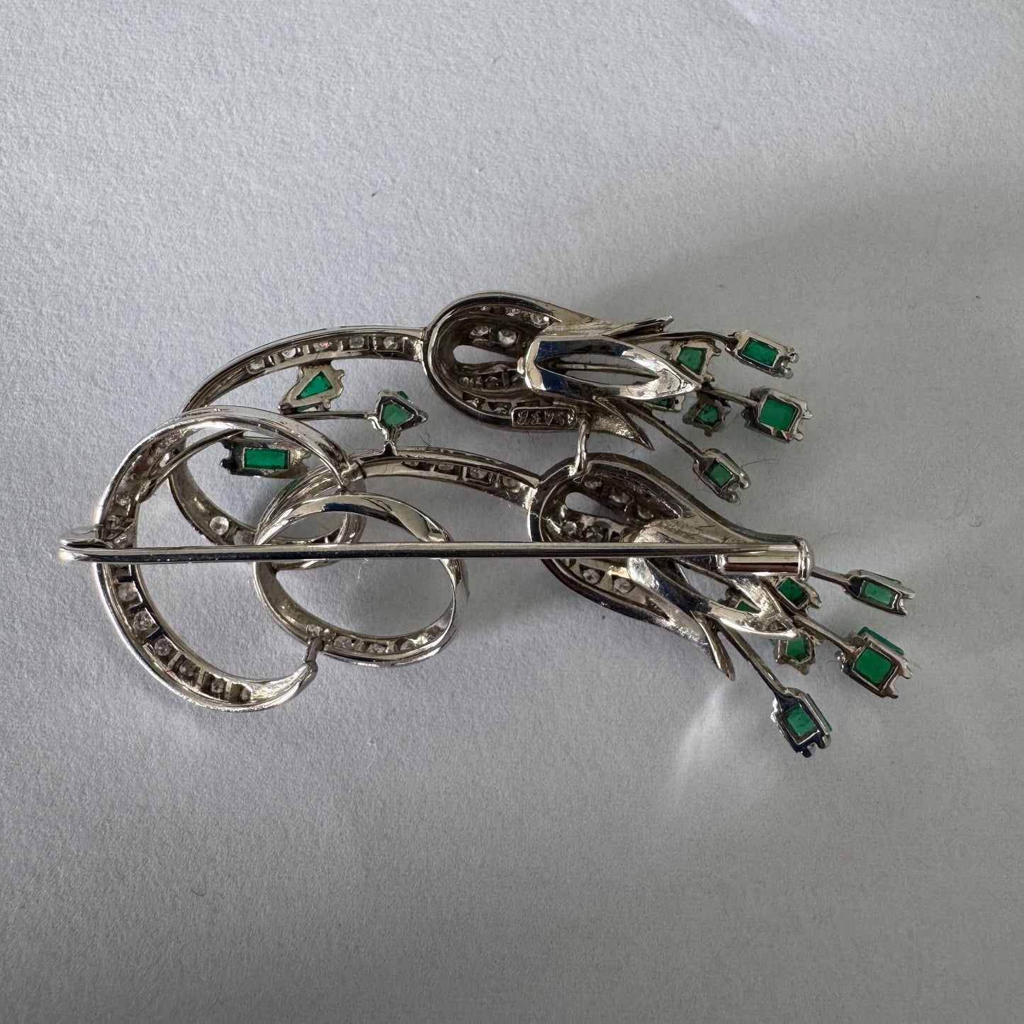 18K gold vintage brooch featuring an elegant floral design set with vibrant Emeralds and sparkling Diamonds.