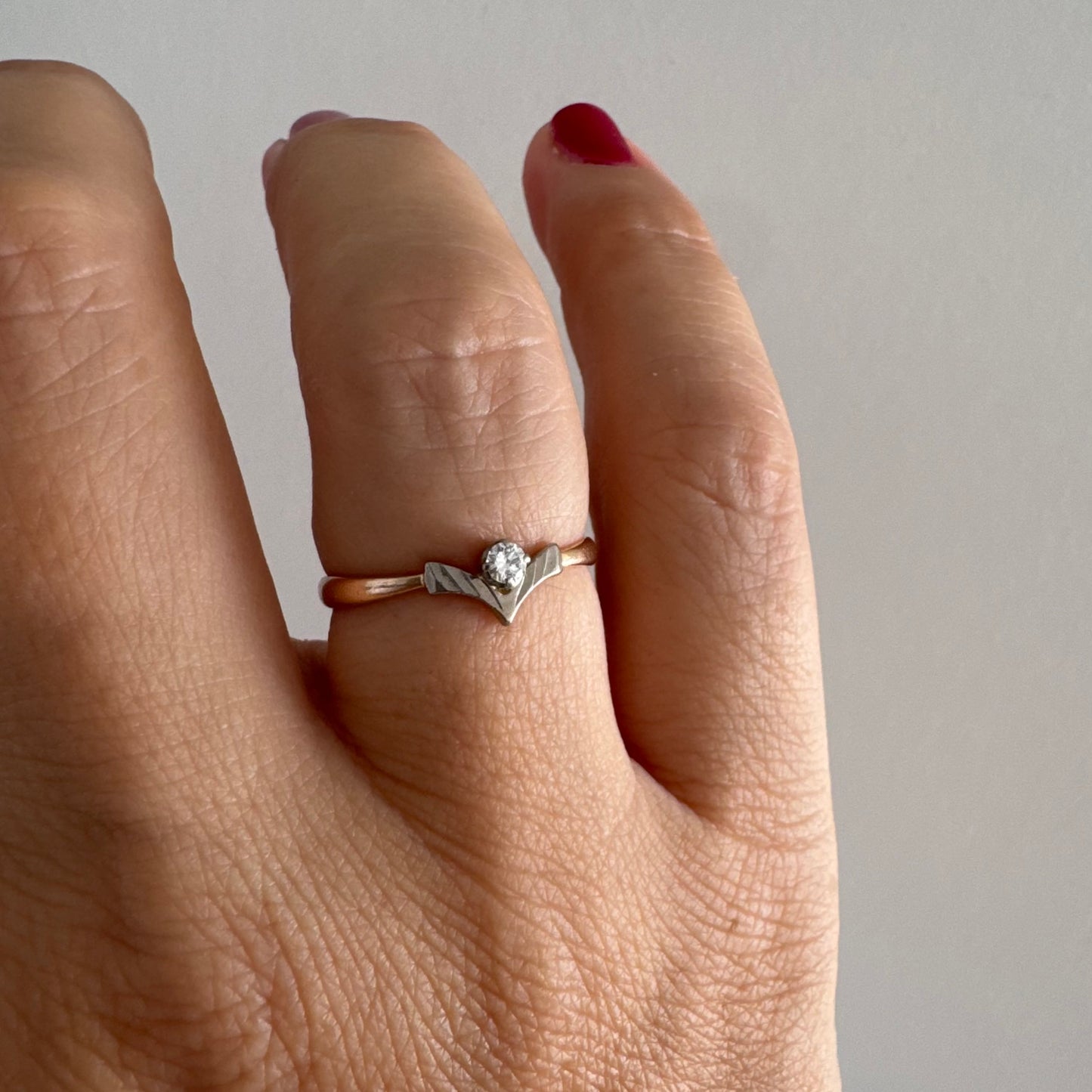 טבעת זהב 14 קראט עם ראש בצורת V מזהב לבן המשובץ יהלום עגול אחד. 