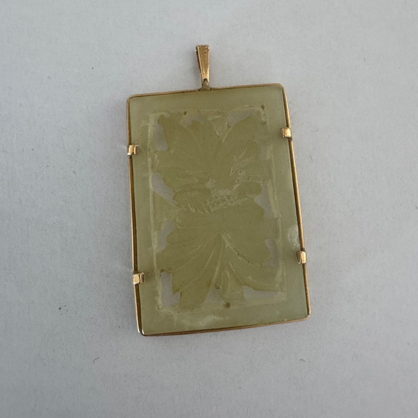 14K gold rectangular pendant set with a hand-carved milky Jade stone