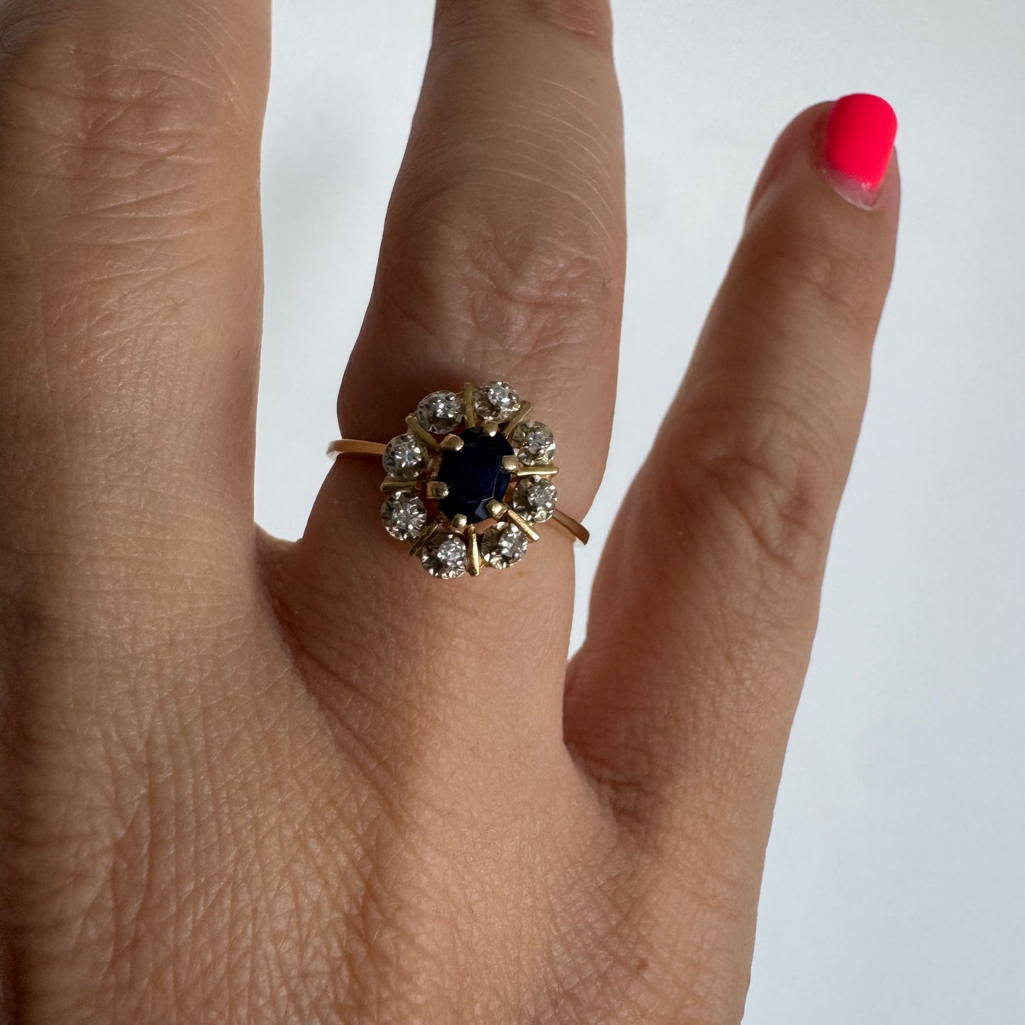 18K gold ring set with a natural blue Sapphire at its center, surrounded by a halo of sparkling Diamonds