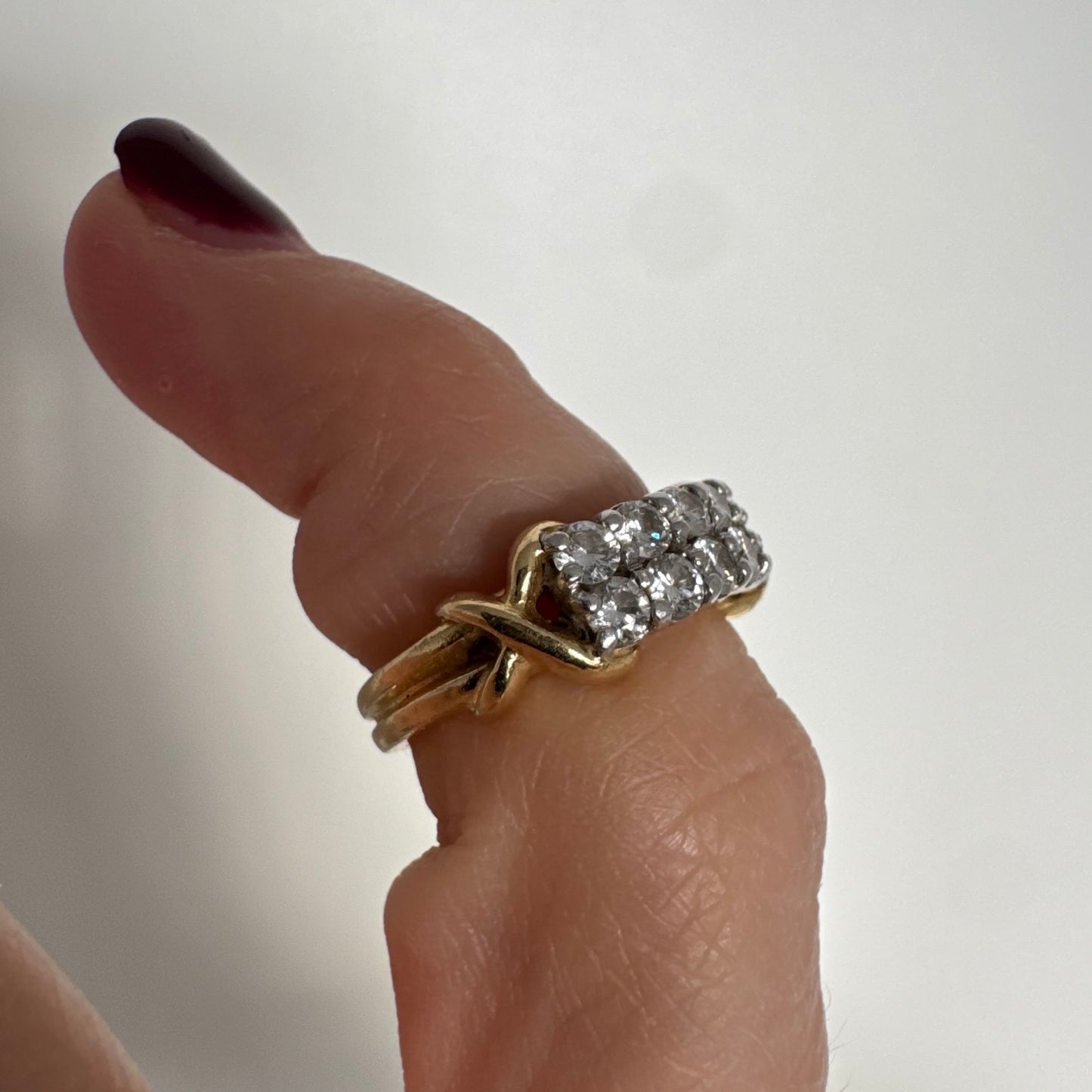 טבעת זהב צהוב 18 קראט משובצת יהלומים עגולים בשתי שורות צפופות, במבנה מלבני מעוגל.