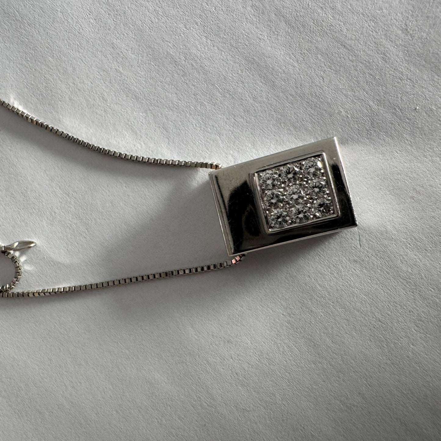 תליון זהב לבן 18 קראט משובץ יהלומים בחיתוך עגול, בשיבוץ צפוף ומדויק היוצר מראה אלגנטי ונקי. 