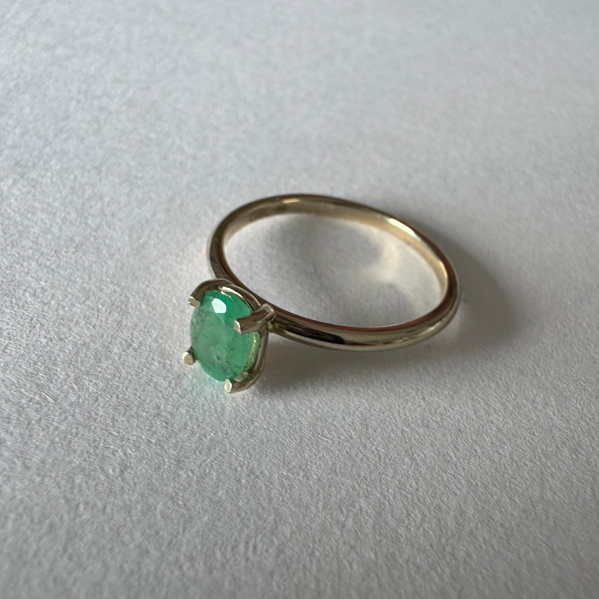 14K gold ring set with an oval-cut Emerald