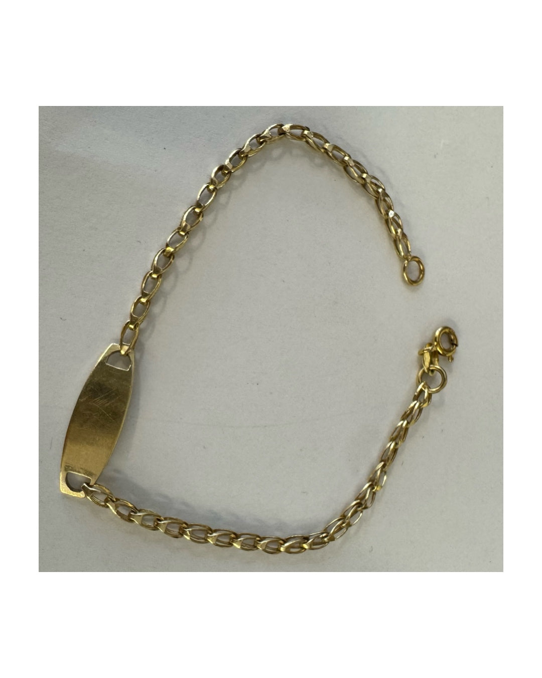 14K gold bracelet featuring a smooth ID plate and a delicate classic chain.