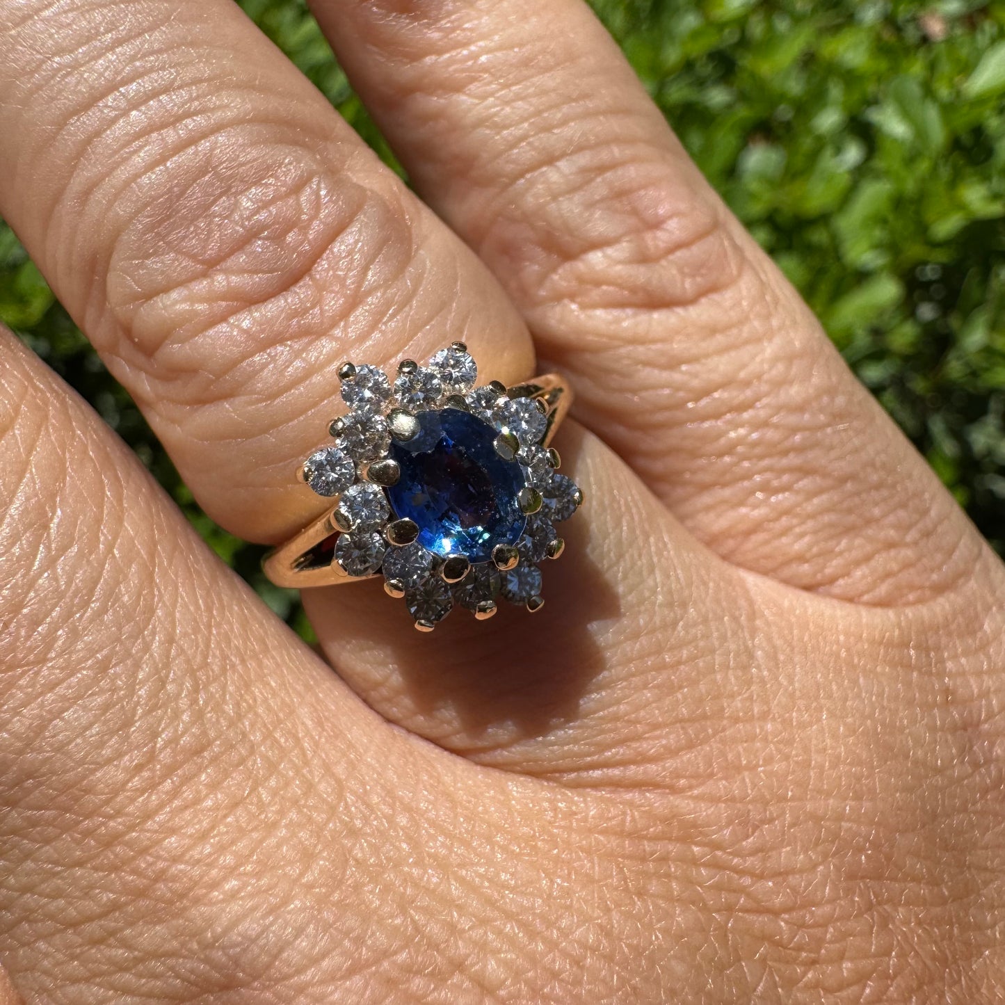 14K gold ring set with a vivid blue Sapphire surrounded by a sparkling halo of brilliant-cut Diamonds