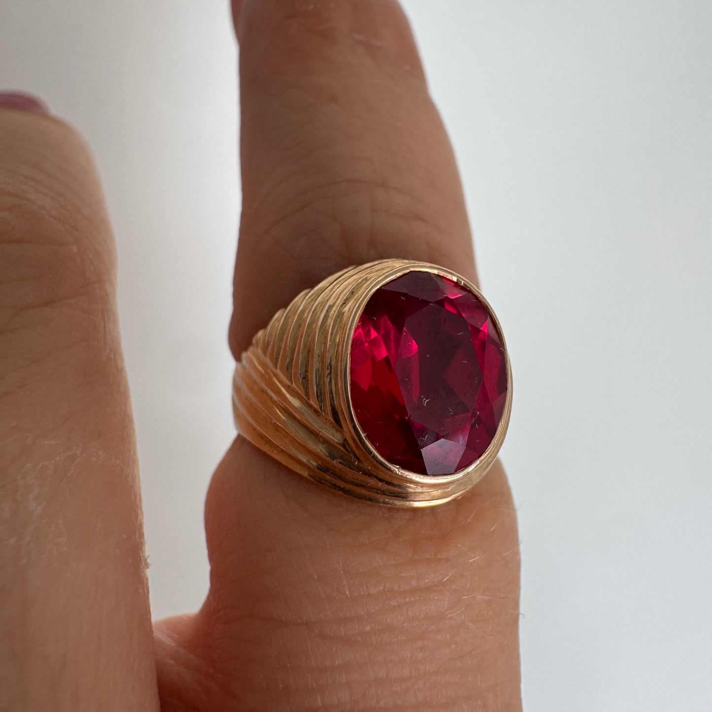 18K gold ring set with a striking oval-cut Ruby gemstone.