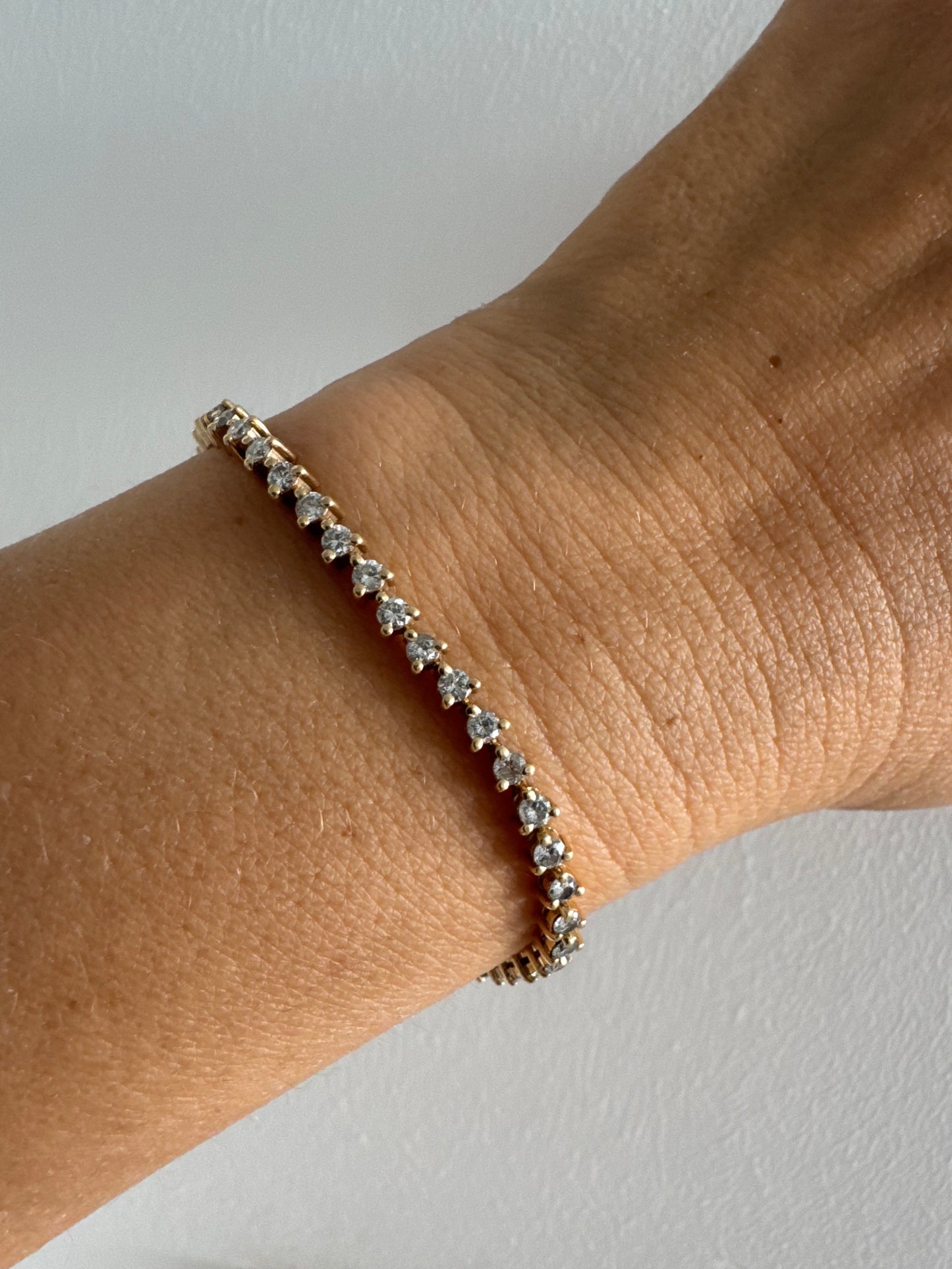 14K gold tennis bracelet set with a continuous line of round Diamonds, creating a delicate and elegant sparkle.