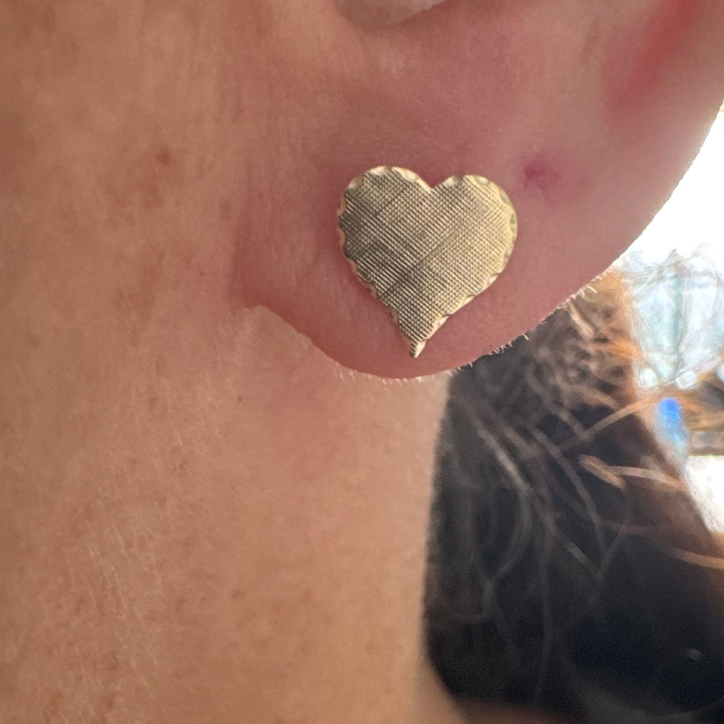 עגילי זהב צהוב 10 קראט בצורת לב, עם טקסטורה עדינה וגימור רך.