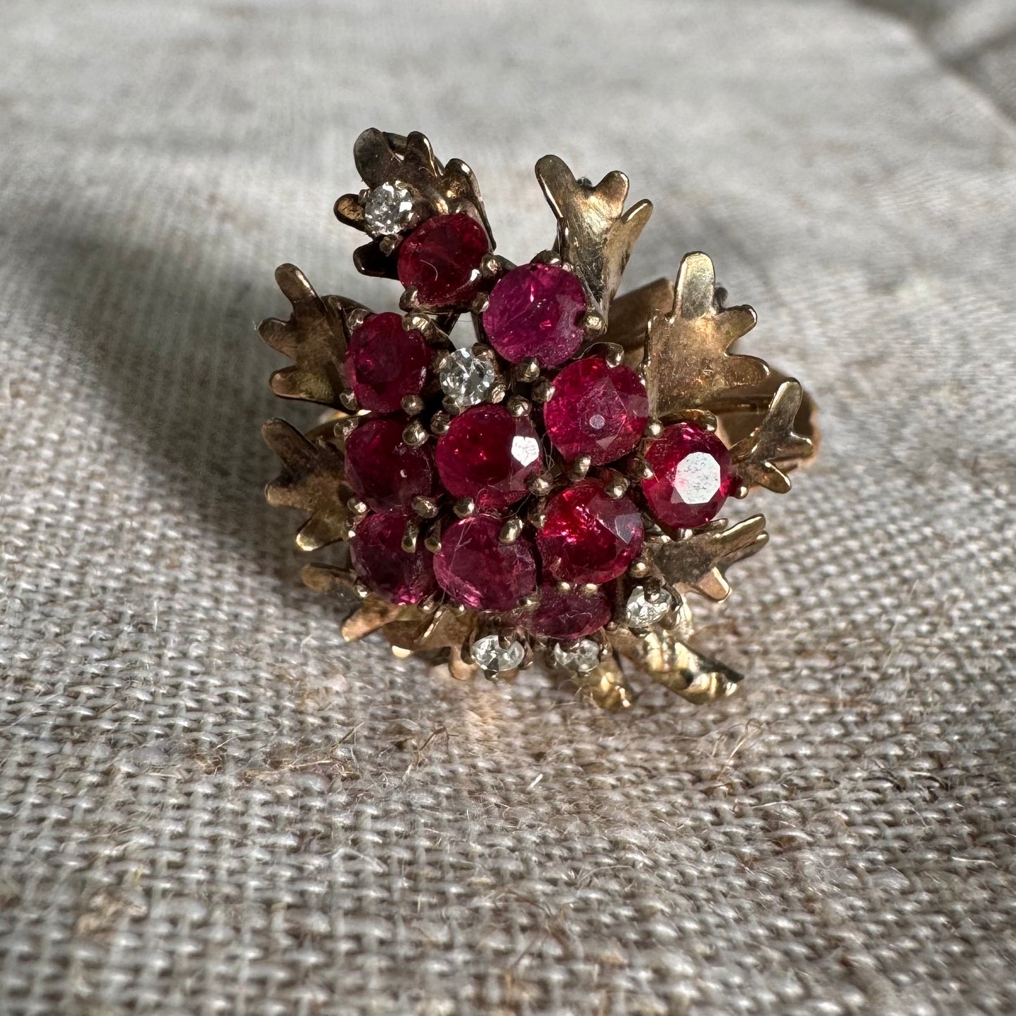 14K gold ring set with a vibrant cluster of deep red rubies and sparkling diamonds.