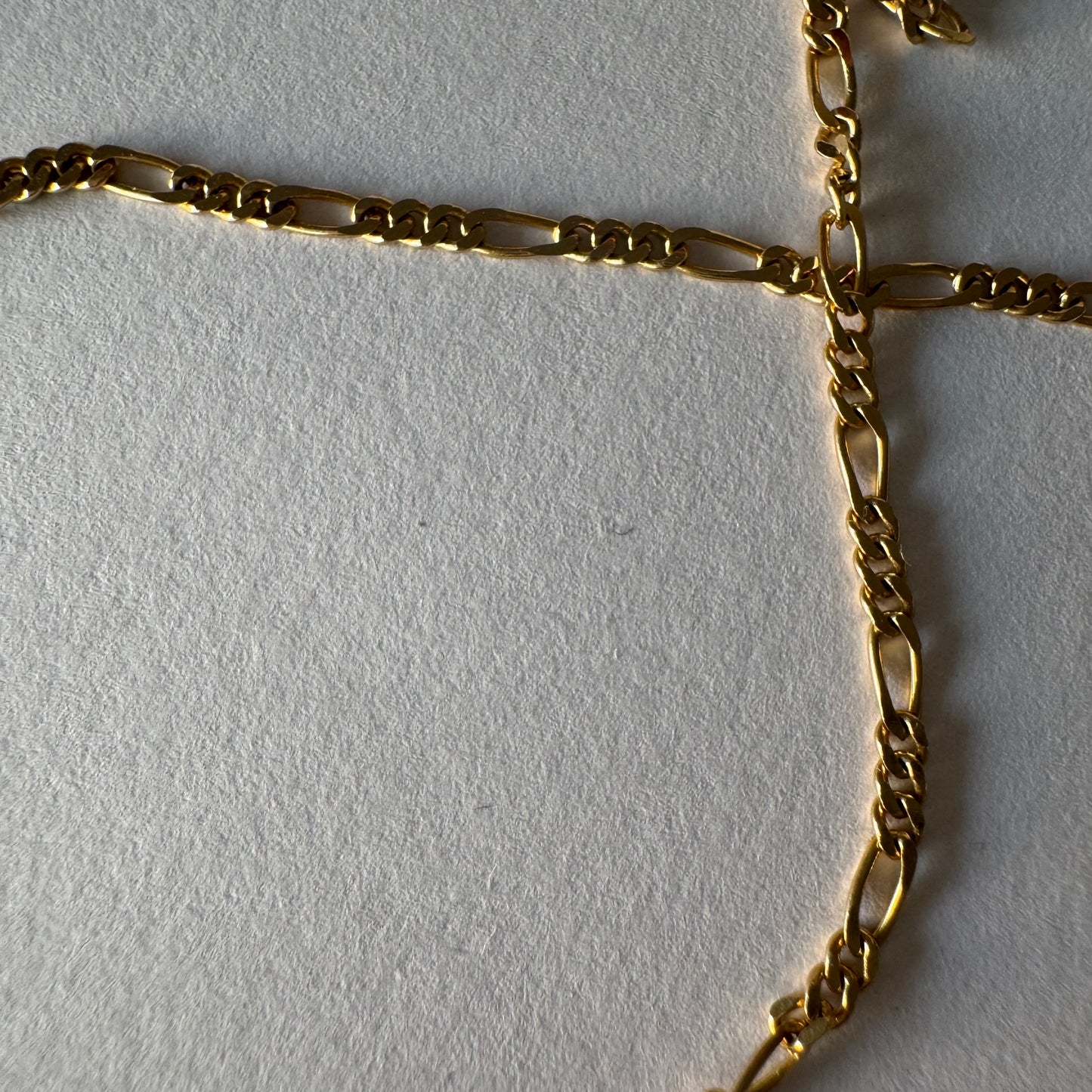 שרשרת זהב צהוב 14 קראט בעיצוב חוליות דקות ומוארכות עם טוויסט עדין שנותן לה מראה אלגנטי ונקי.