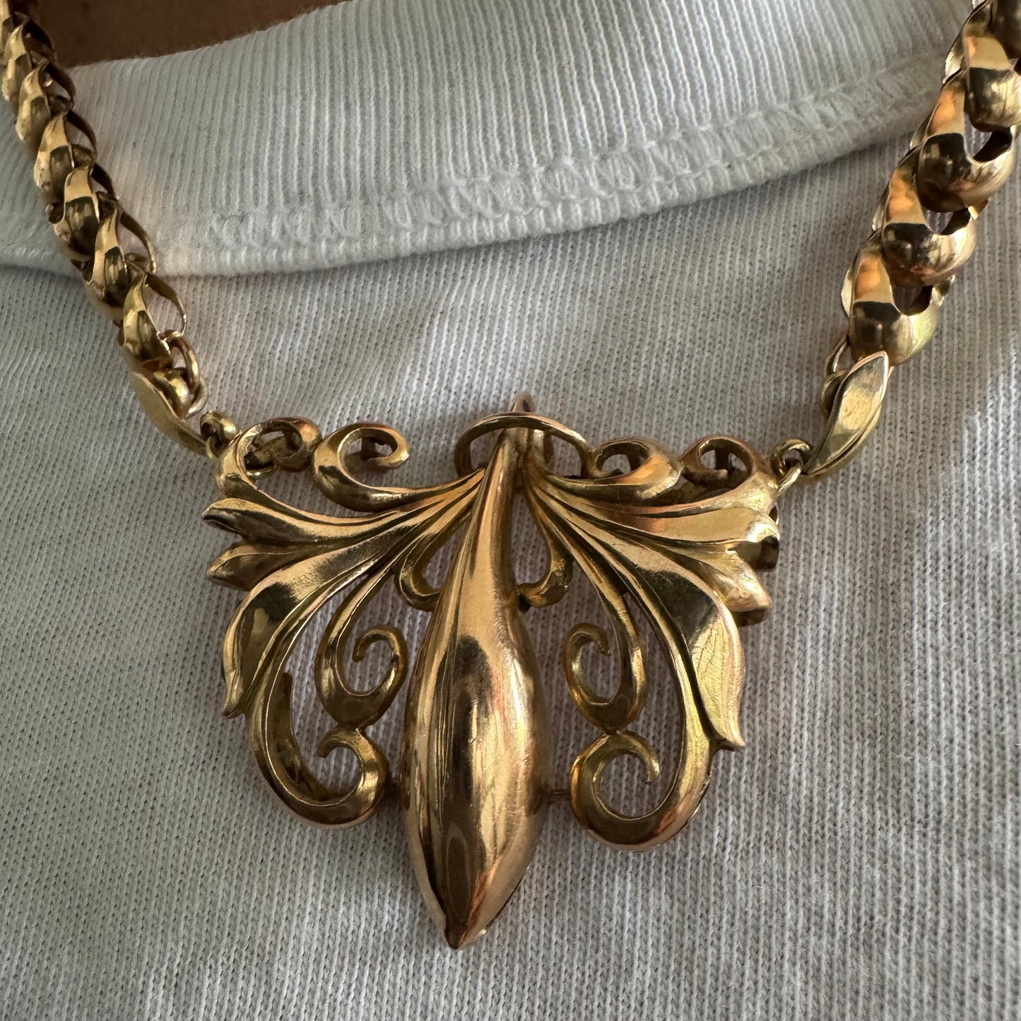 שרשרת זהב 14 קראט בעלת עיטור פלר דה ליס (Fleur-de-lis) אמנותי, המעוצב בקווים מעוגלים של עלי שושן בסגנון אר נובו.