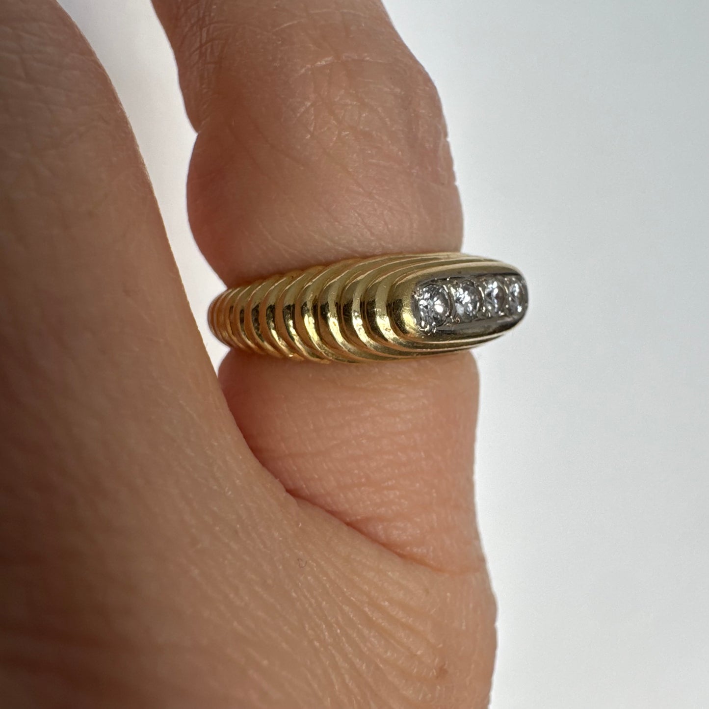 14K gold elongated oval ring set with five round Diamonds in a channel setting.