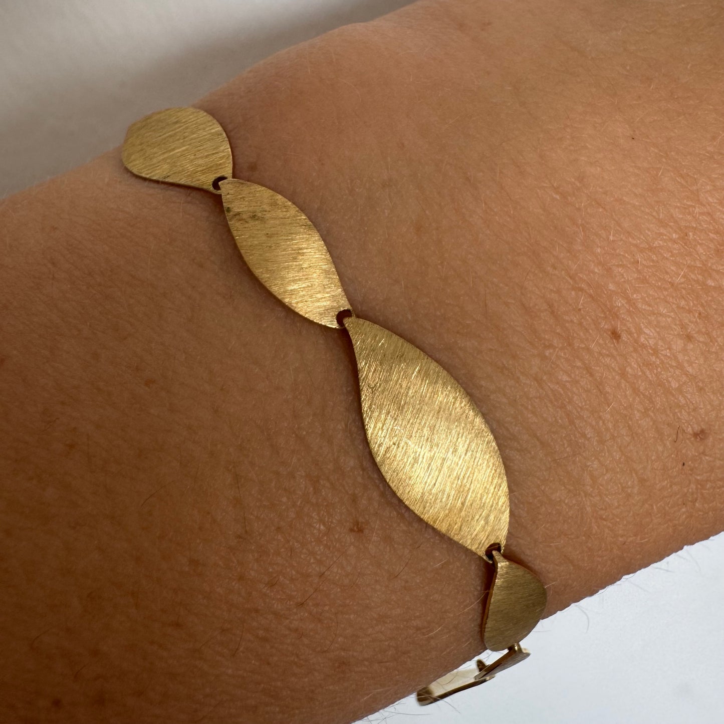 צמיד יוקרתי של המותג H.Stern, עשוי זהב 18 קראט, בעיצוב עלים מחוספסים במראה משי מט. 