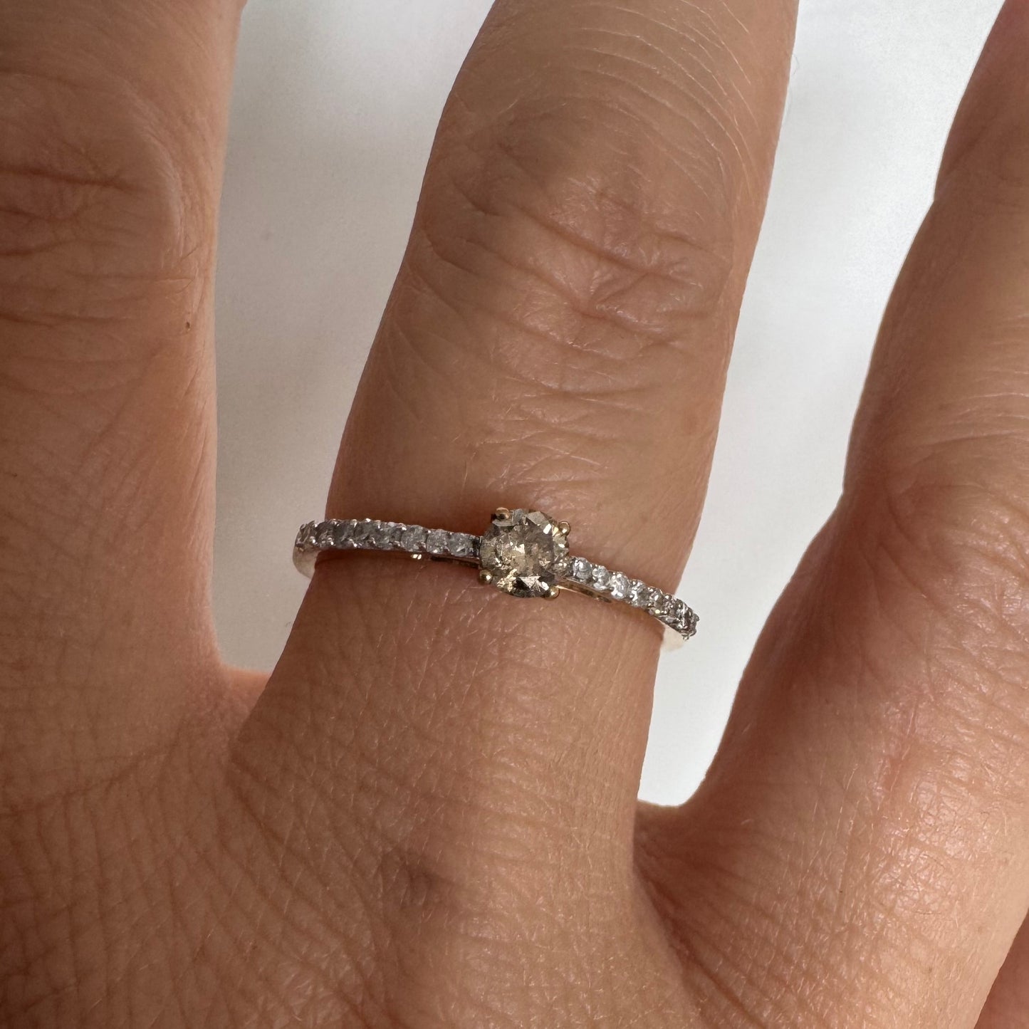 9K gold ring set with a central Diamond and sparkling Diamonds along the band