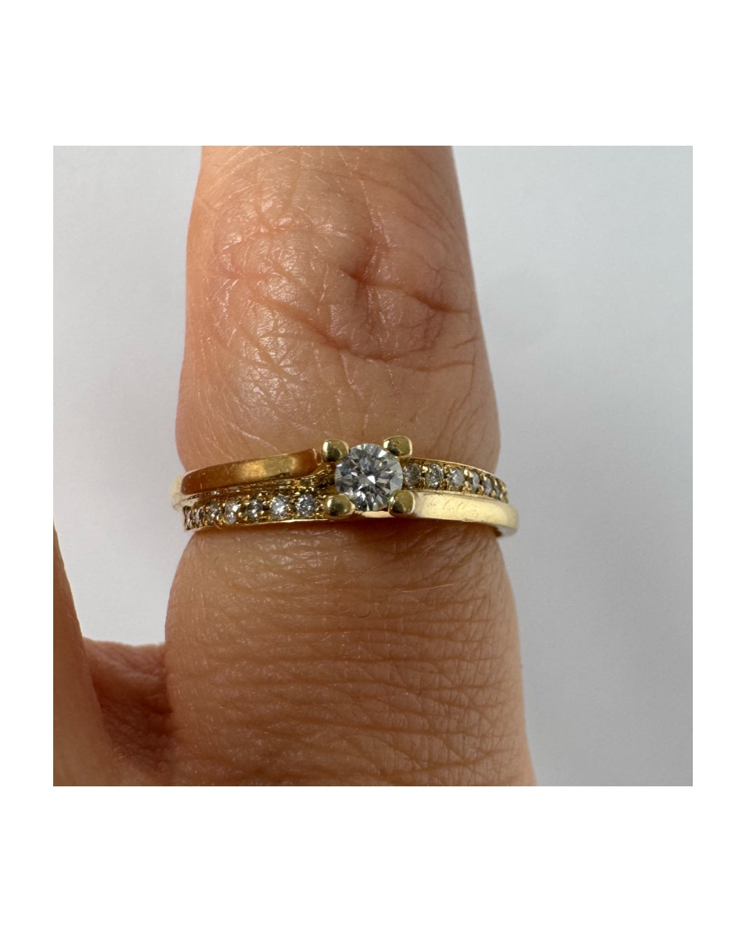14K yellow gold ring set with a round brilliant-cut diamond and a pavé diamond band ￼