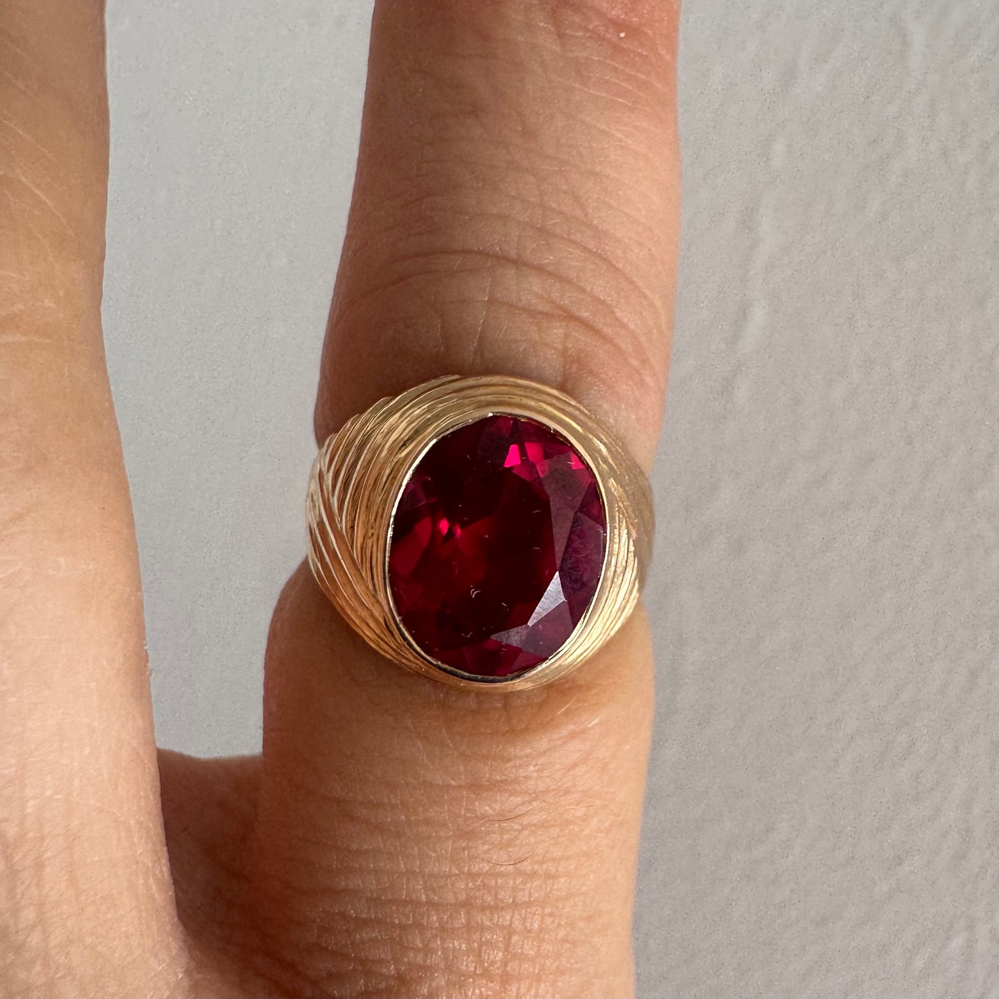 18K gold ring set with a striking oval-cut Ruby gemstone.